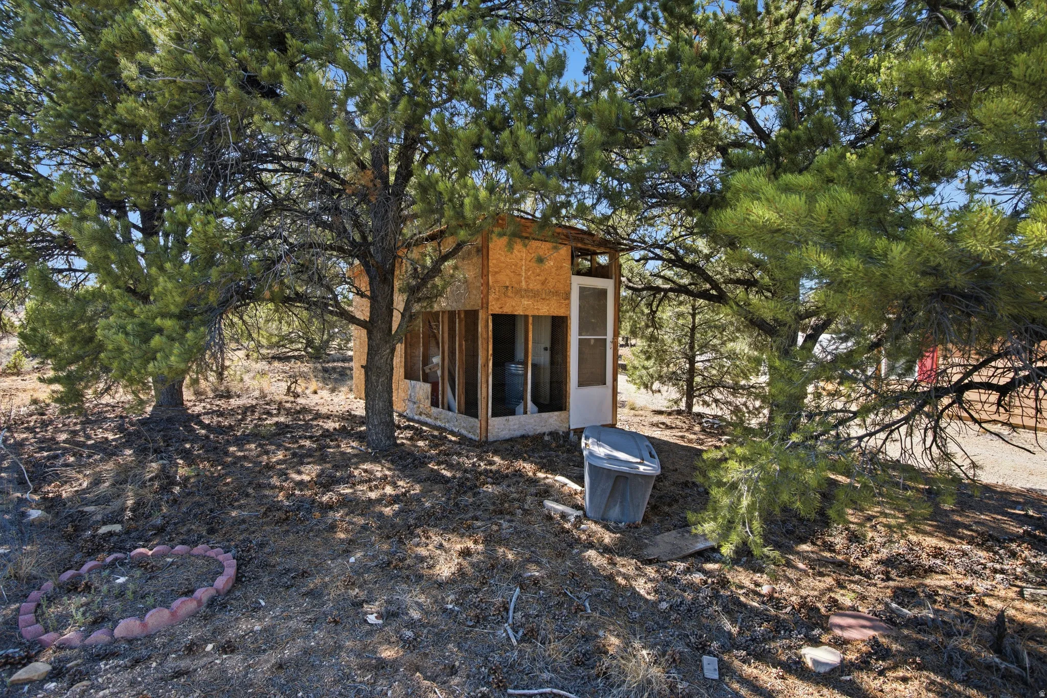 Back of house featuring a sunroom and an outdoor structure