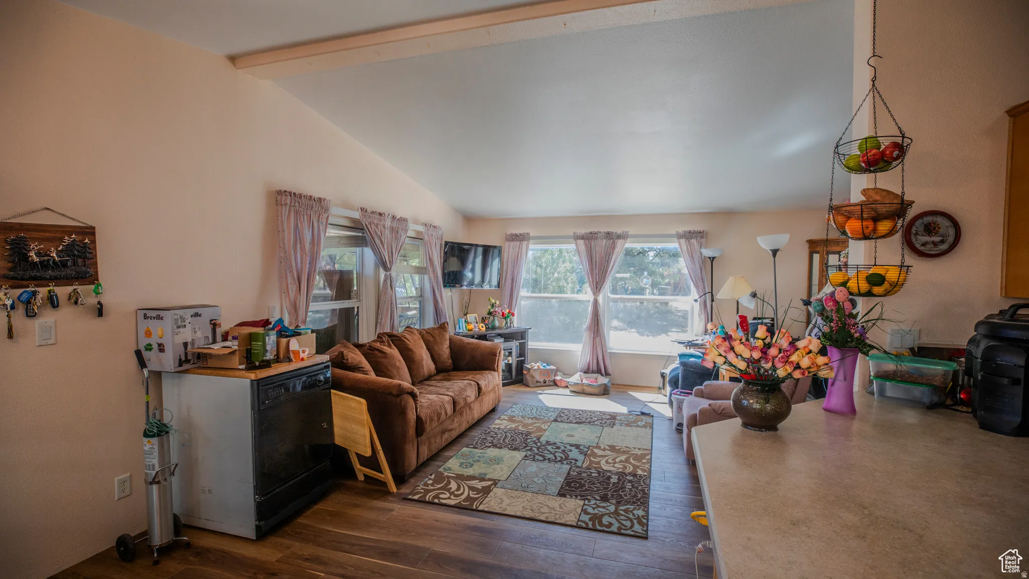Living room featuring dark wood-type flooring and vaulted ceiling with beams