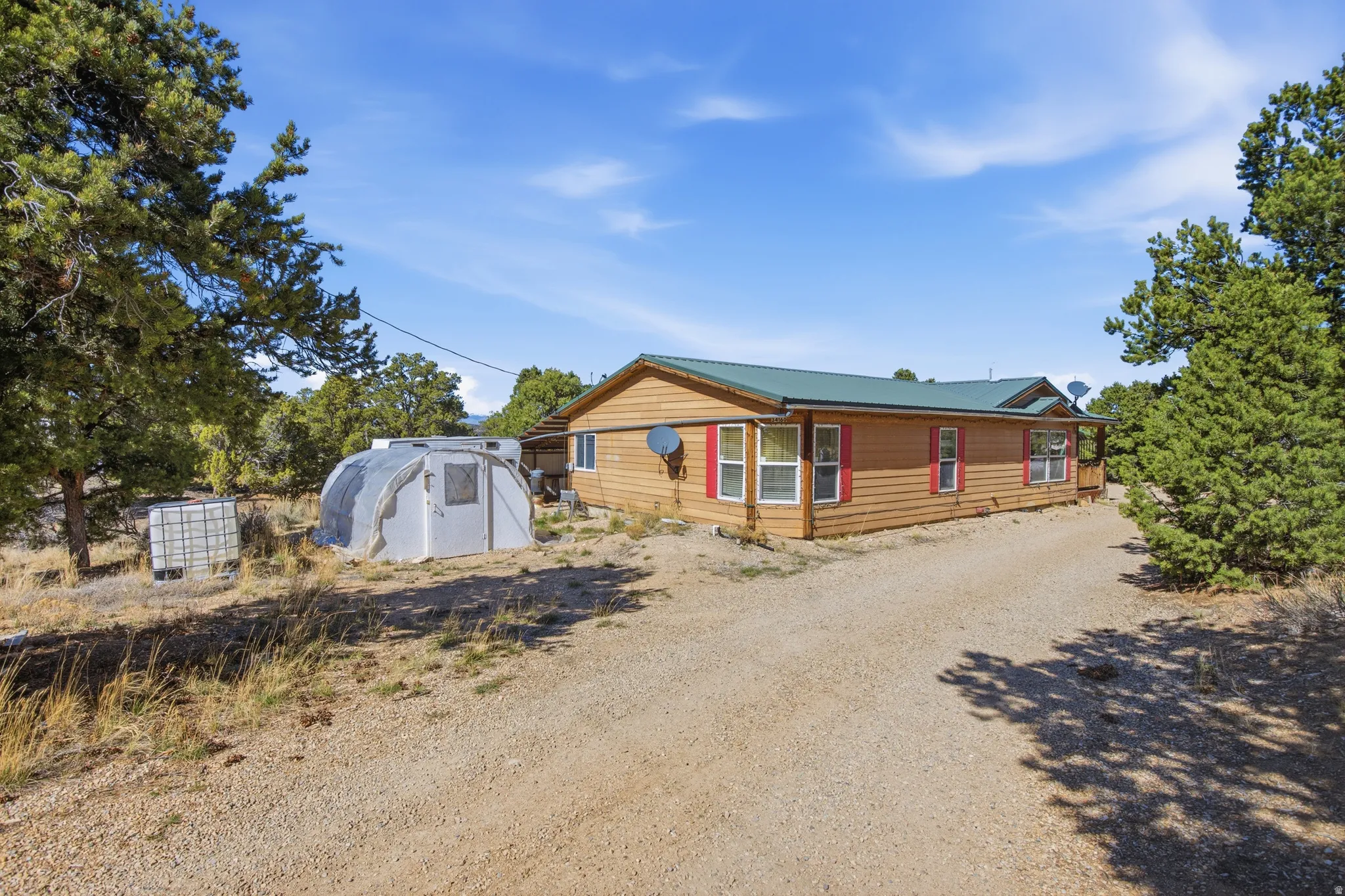 View of front of home featuring driveway and an outbuilding