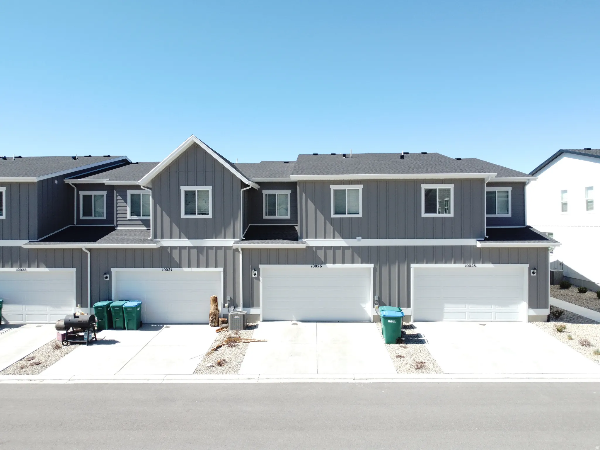 View of front of house featuring board and batten siding, an attached garage, concrete driveway, and a residential view