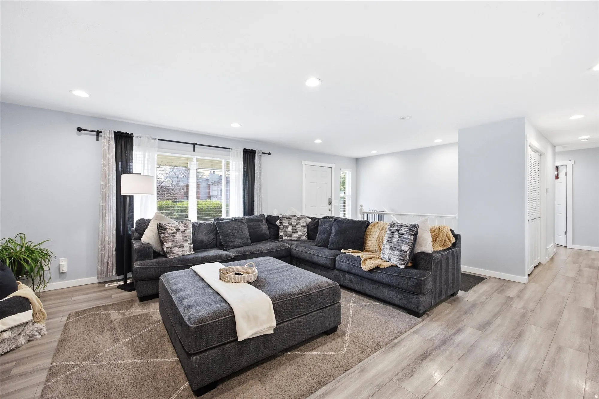 Living room with light wood finished floors and recessed lighting