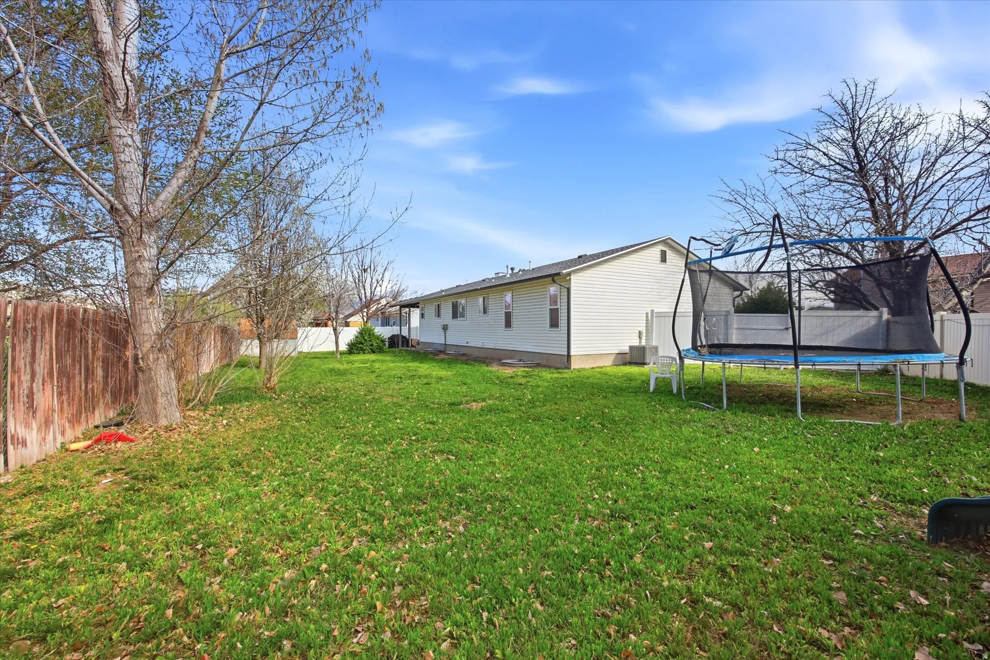 Fenced backyard with a trampoline