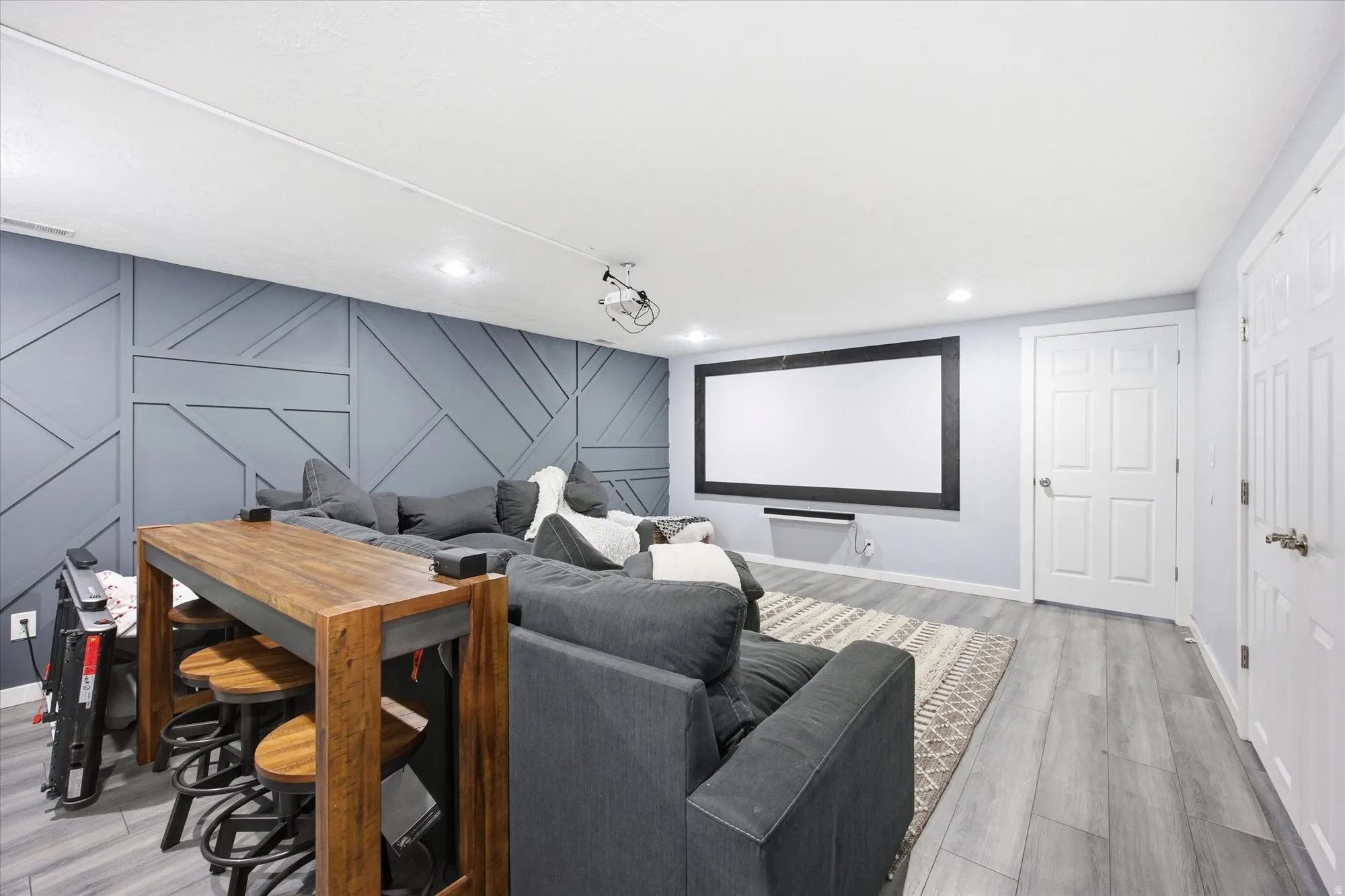 Home theater room with a decorative wall, light wood finished floors, and an accent wall