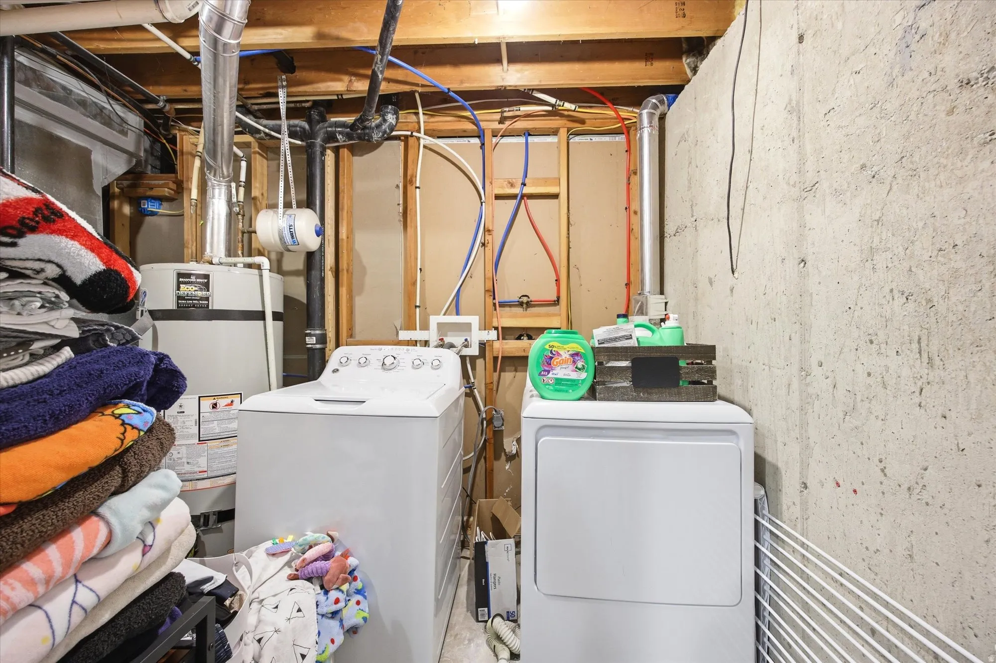 Laundry area with water heater and washing machine and dryer