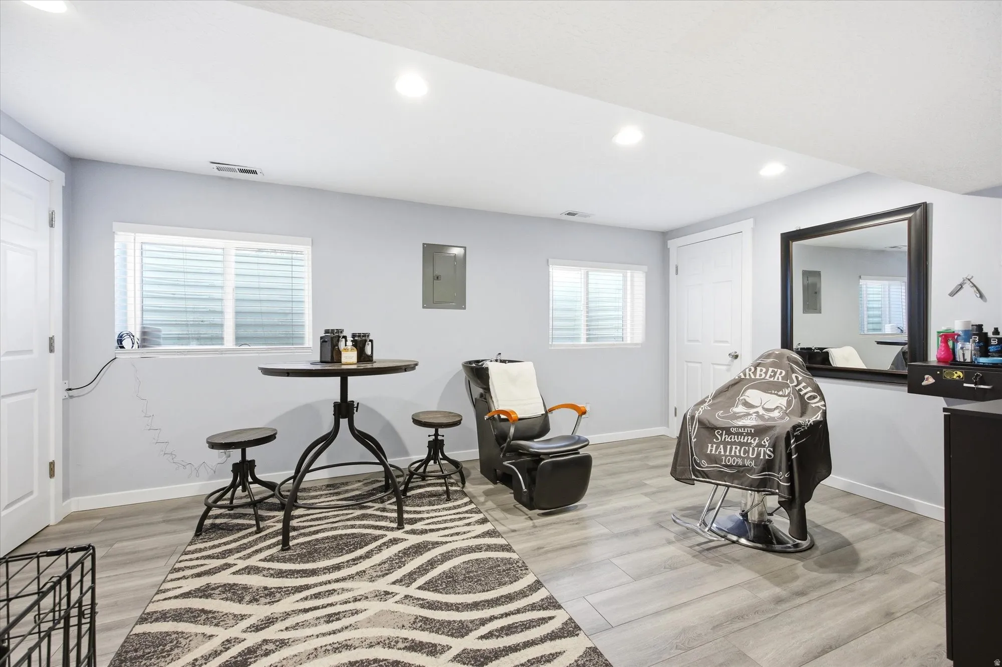 Living area with light wood finished floors, recessed lighting, and electric panel