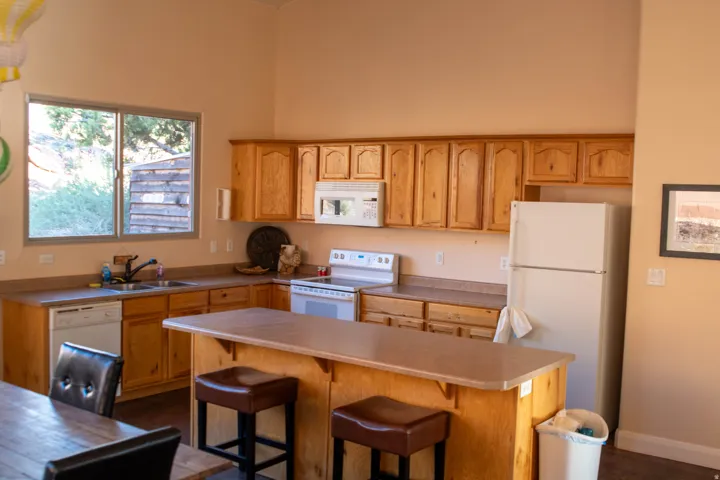 Kitchen with white appliances, a breakfast bar area, and light countertops