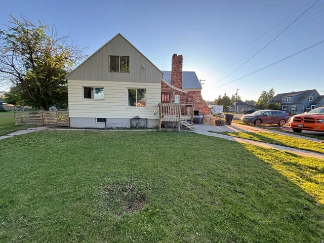 Back of property with board and batten siding, a chimney, and a residential view