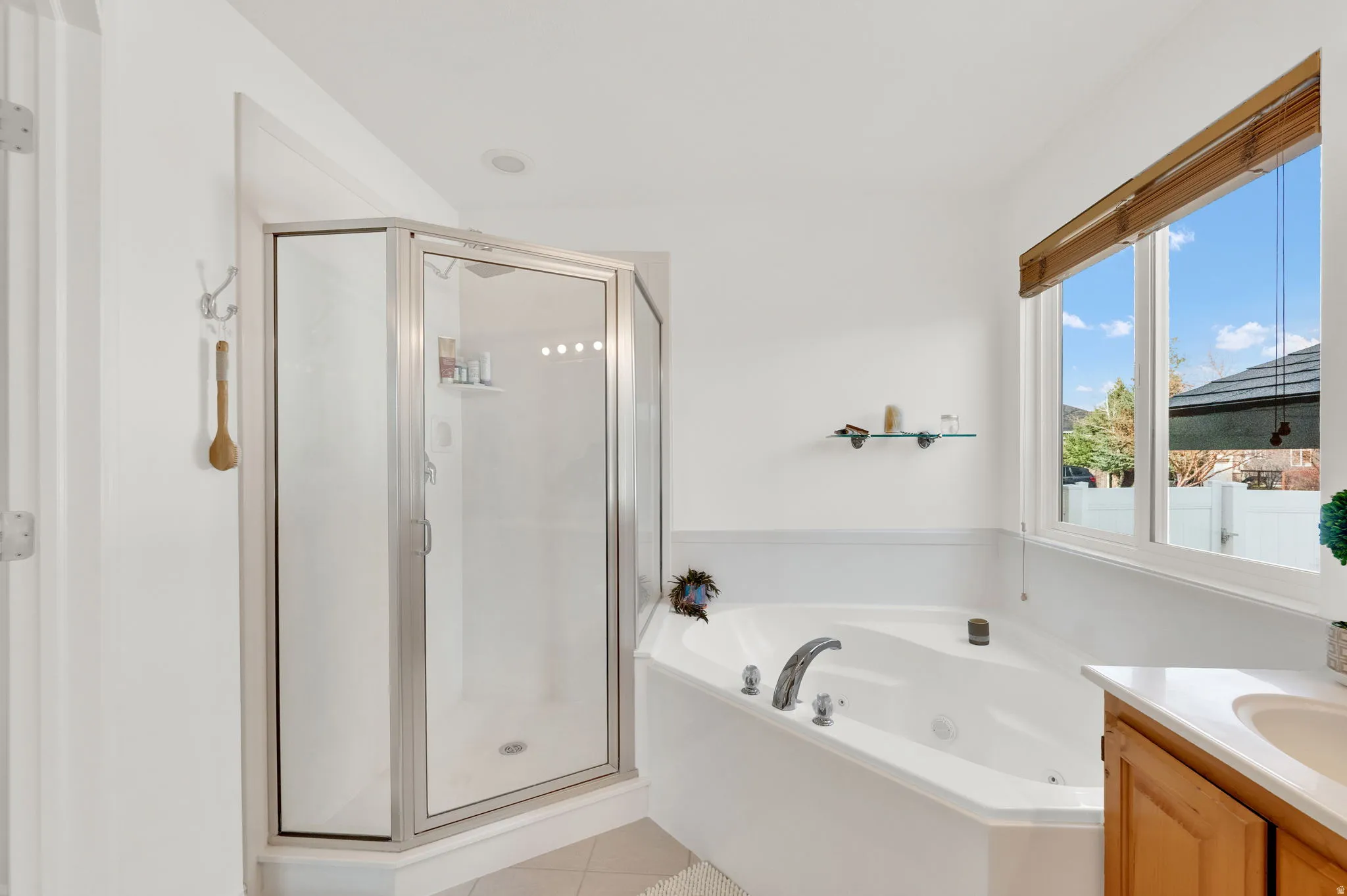 Primary full bath featuring vanity, a shower stall, light tile patterned flooring, and a jetted tub