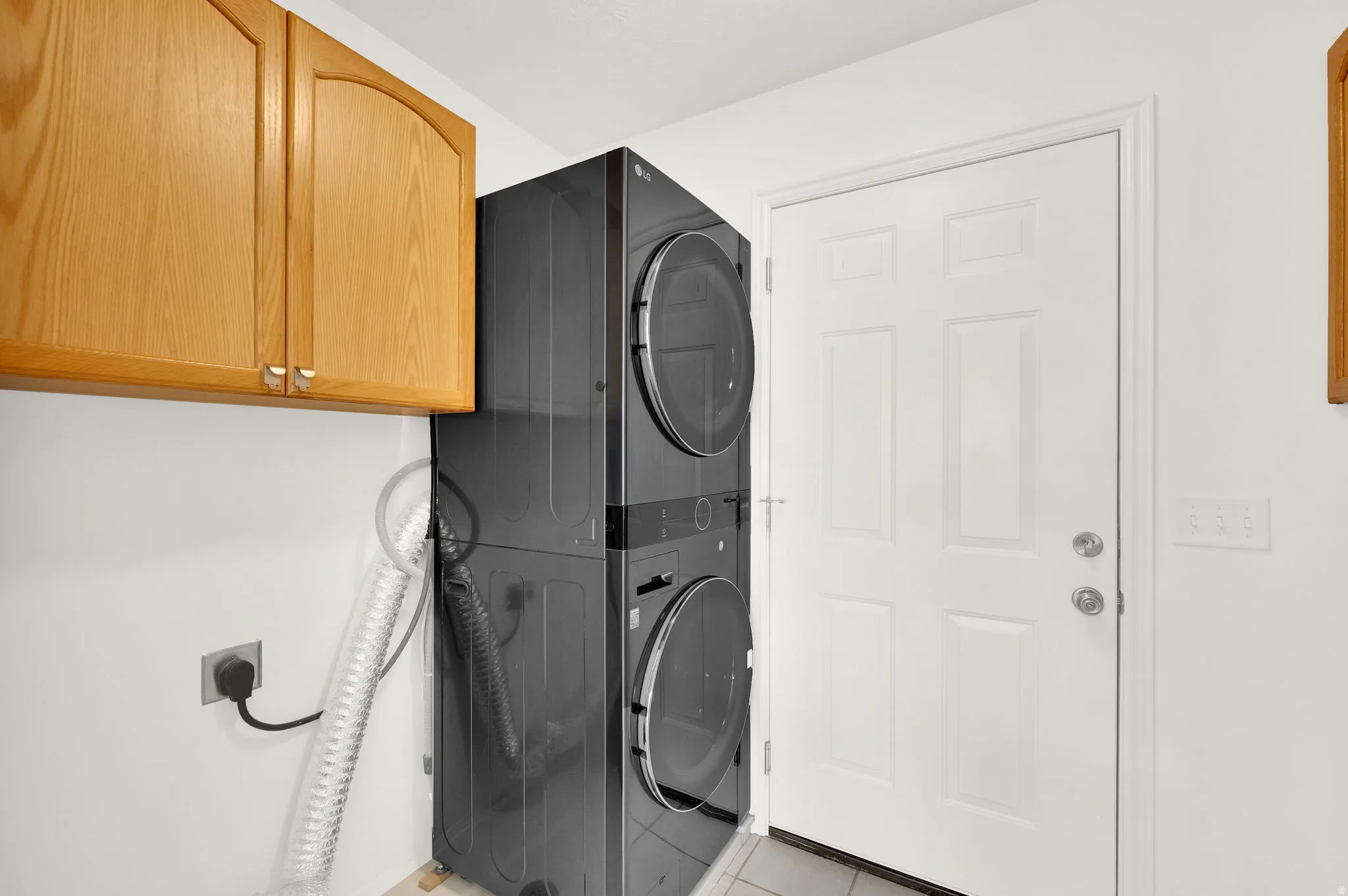 Laundry room featuring stackable washer and dryer with an option of side by side.