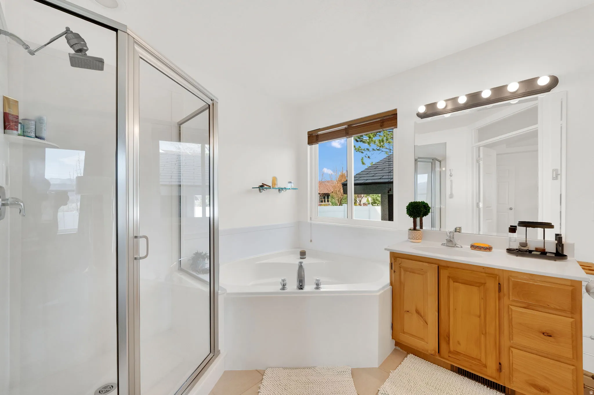 Primary full bathroom featuring vanity, a stall shower, a garden tub, and light tile patterned flooring
