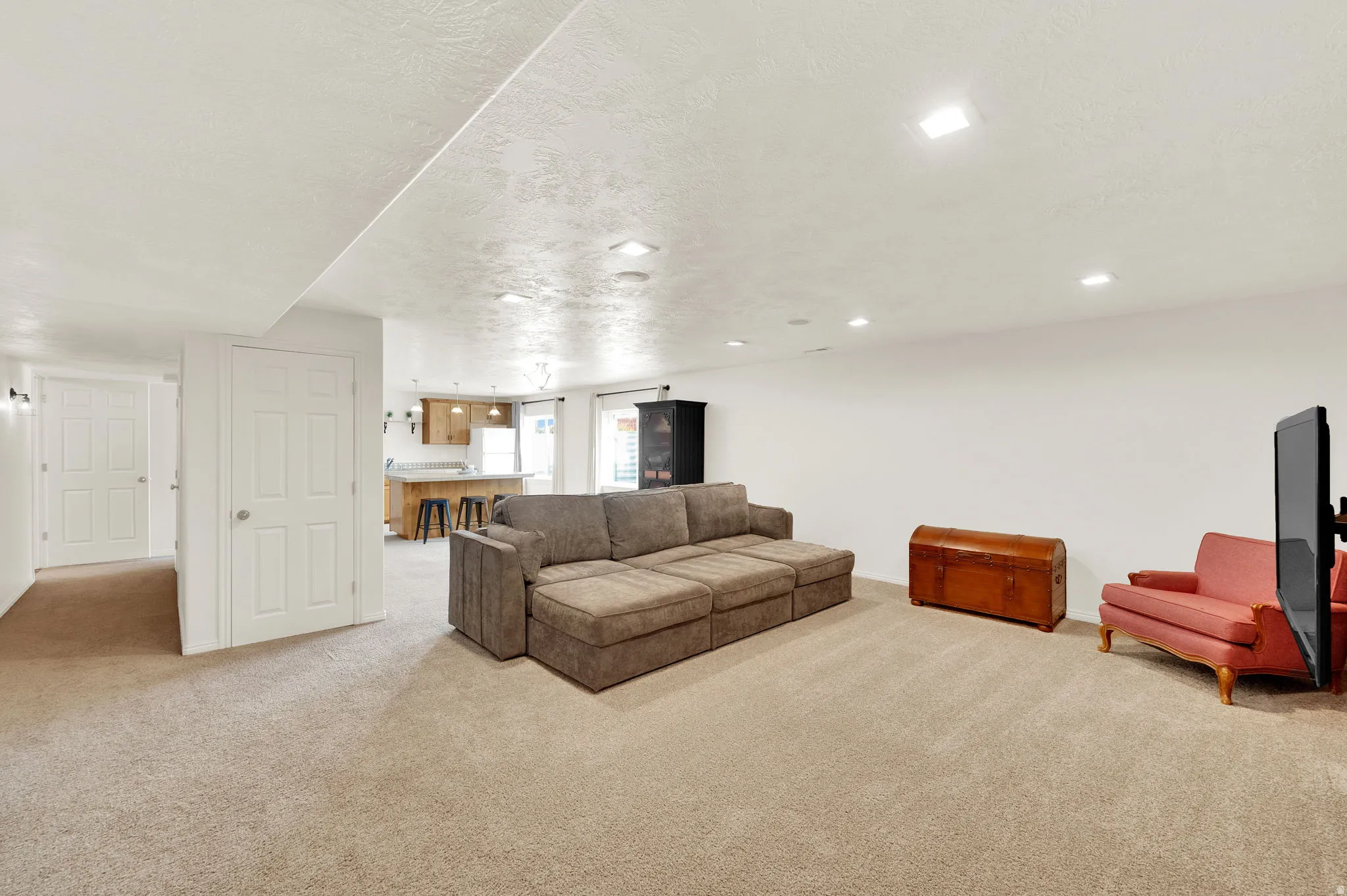 Rec room/Living room featuring light carpet and a textured ceiling