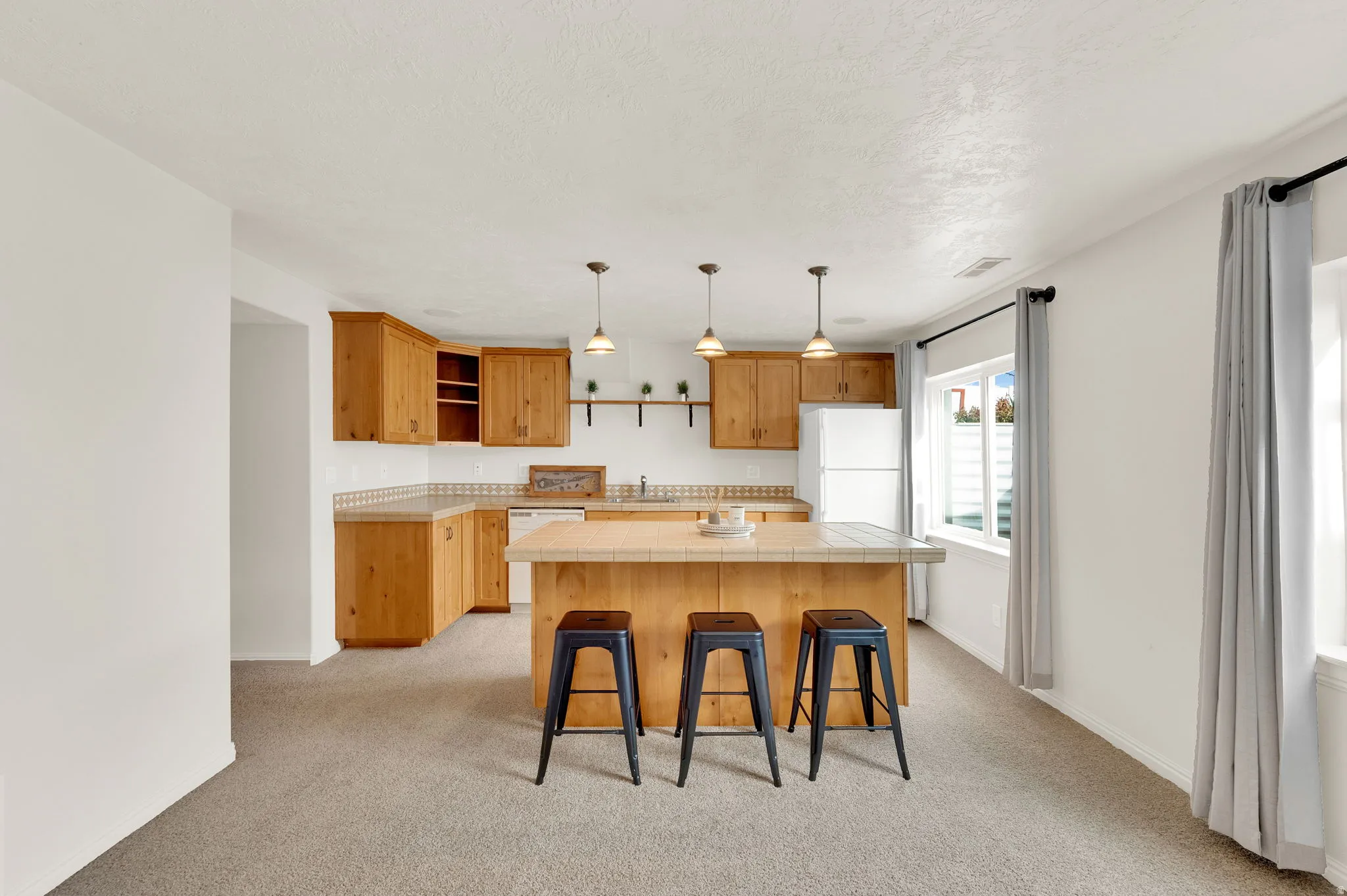 Basement kitchenette including dishwasher and refrigerator.