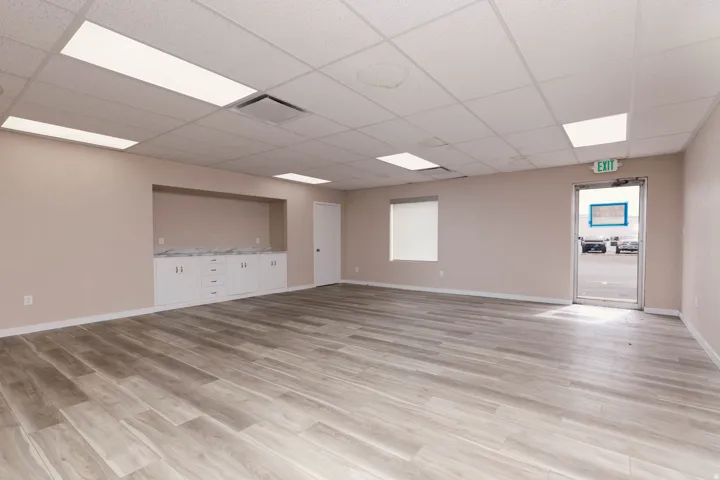 Empty room with light wood-type flooring and a paneled ceiling