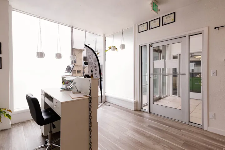 Home office with light wood finished floors and a textured wall