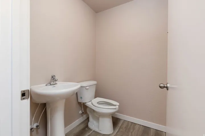 Half bath with toilet and light wood-type flooring