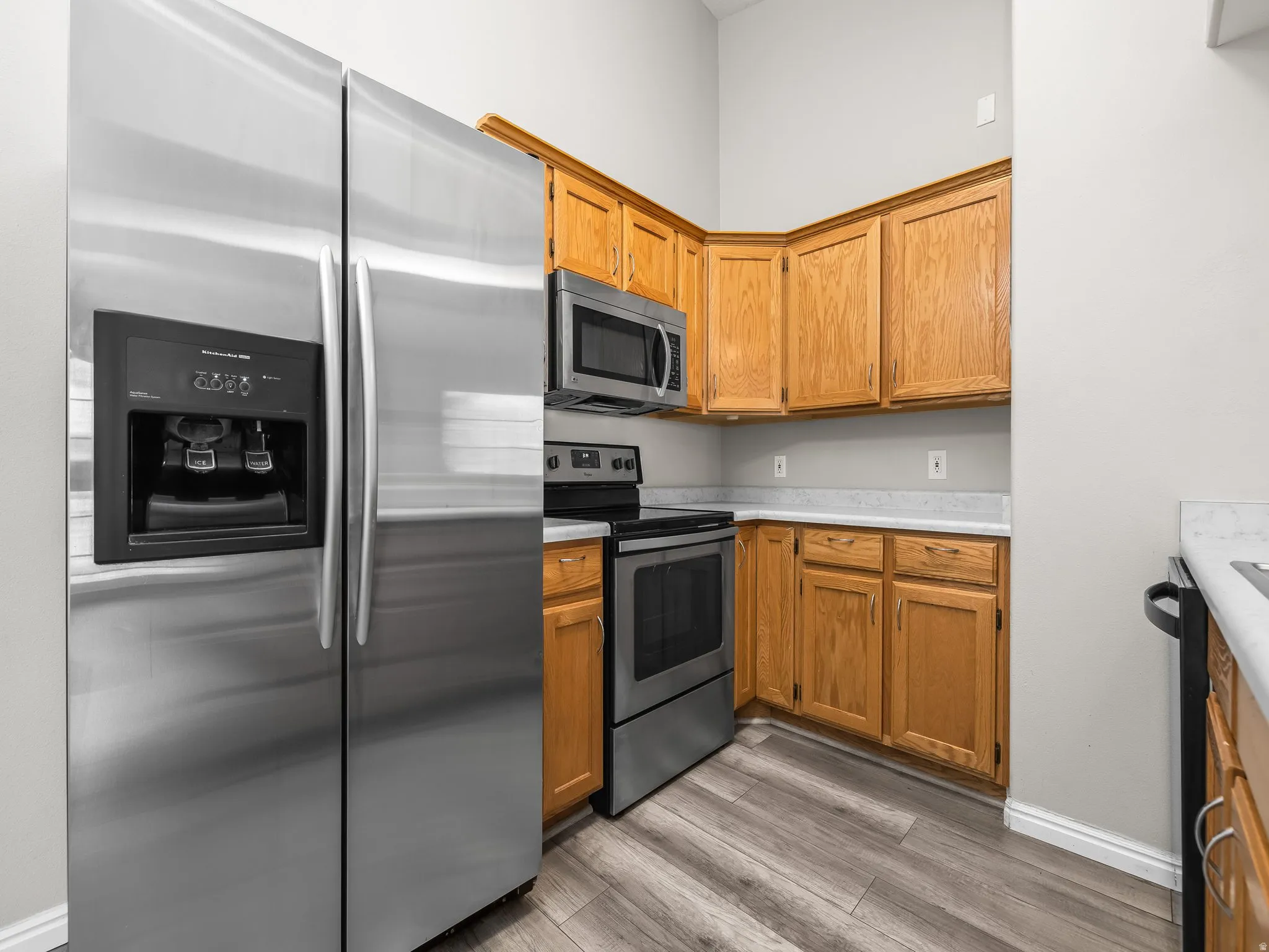 Kitchen featuring stainless steel appliances, light countertops, light wood-type flooring, and wood finish cabinetry