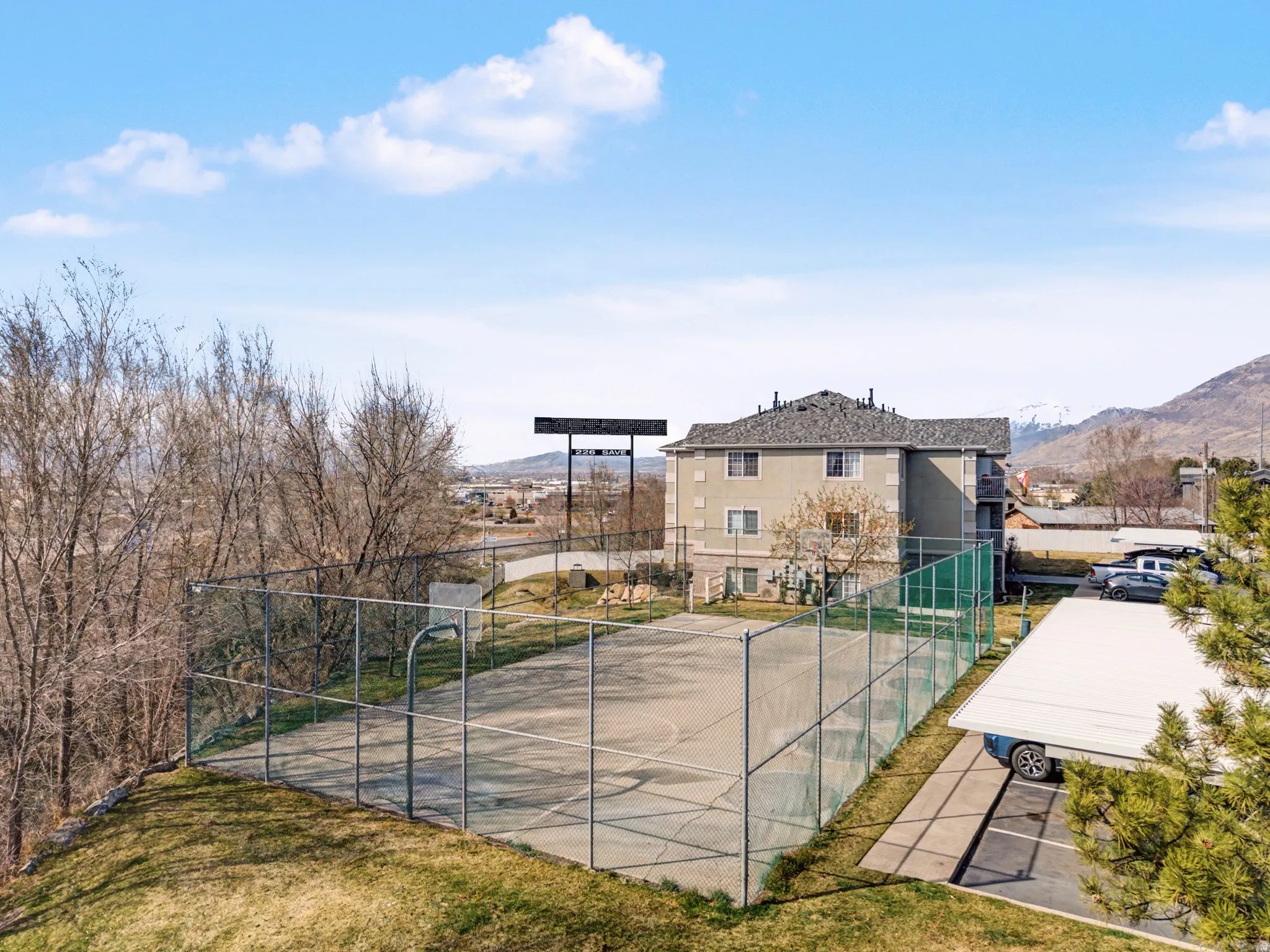 View of tennis court featuring a mountain view and basketball hoop