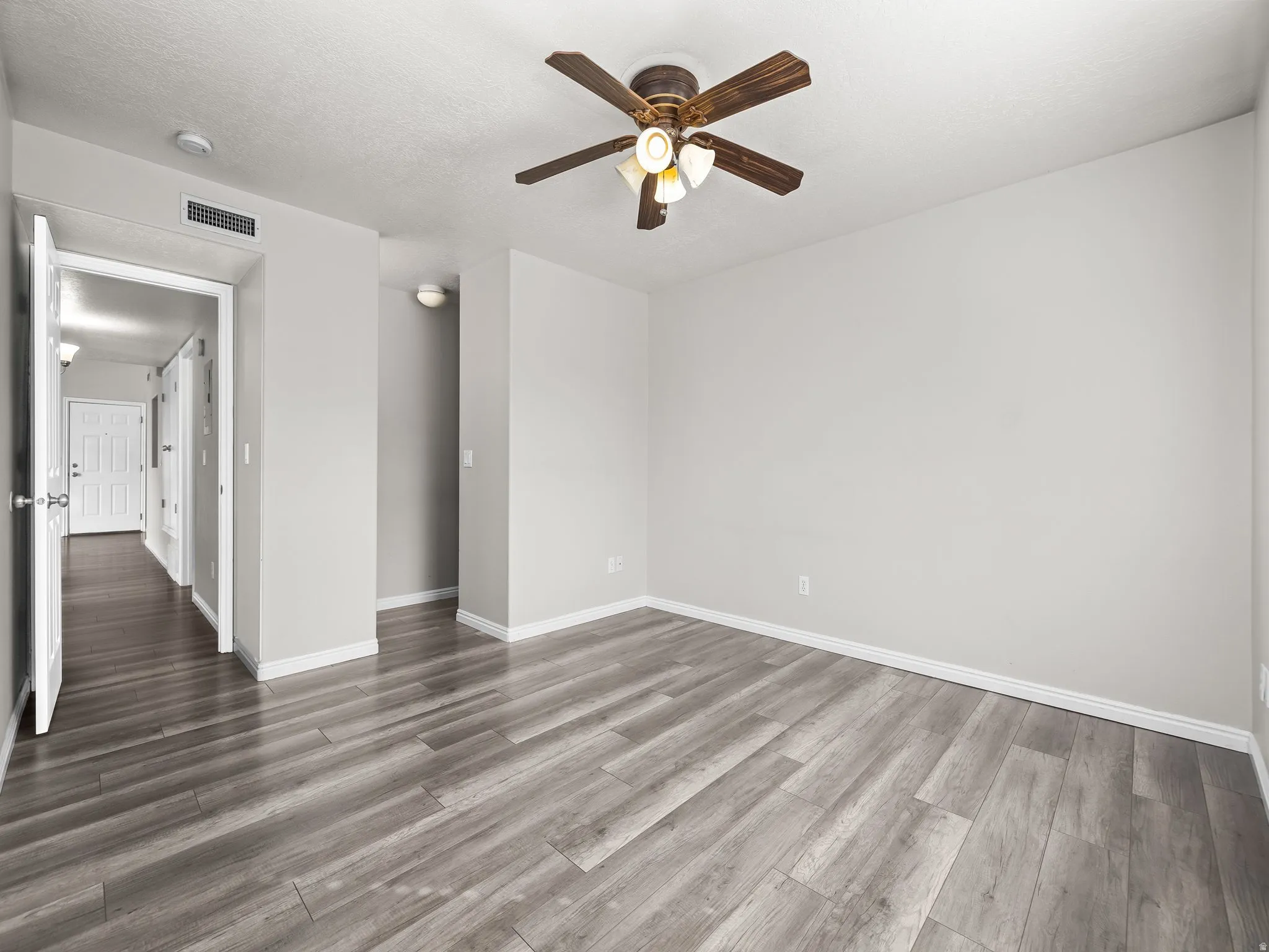 Empty room featuring a ceiling fan and wood finished floors