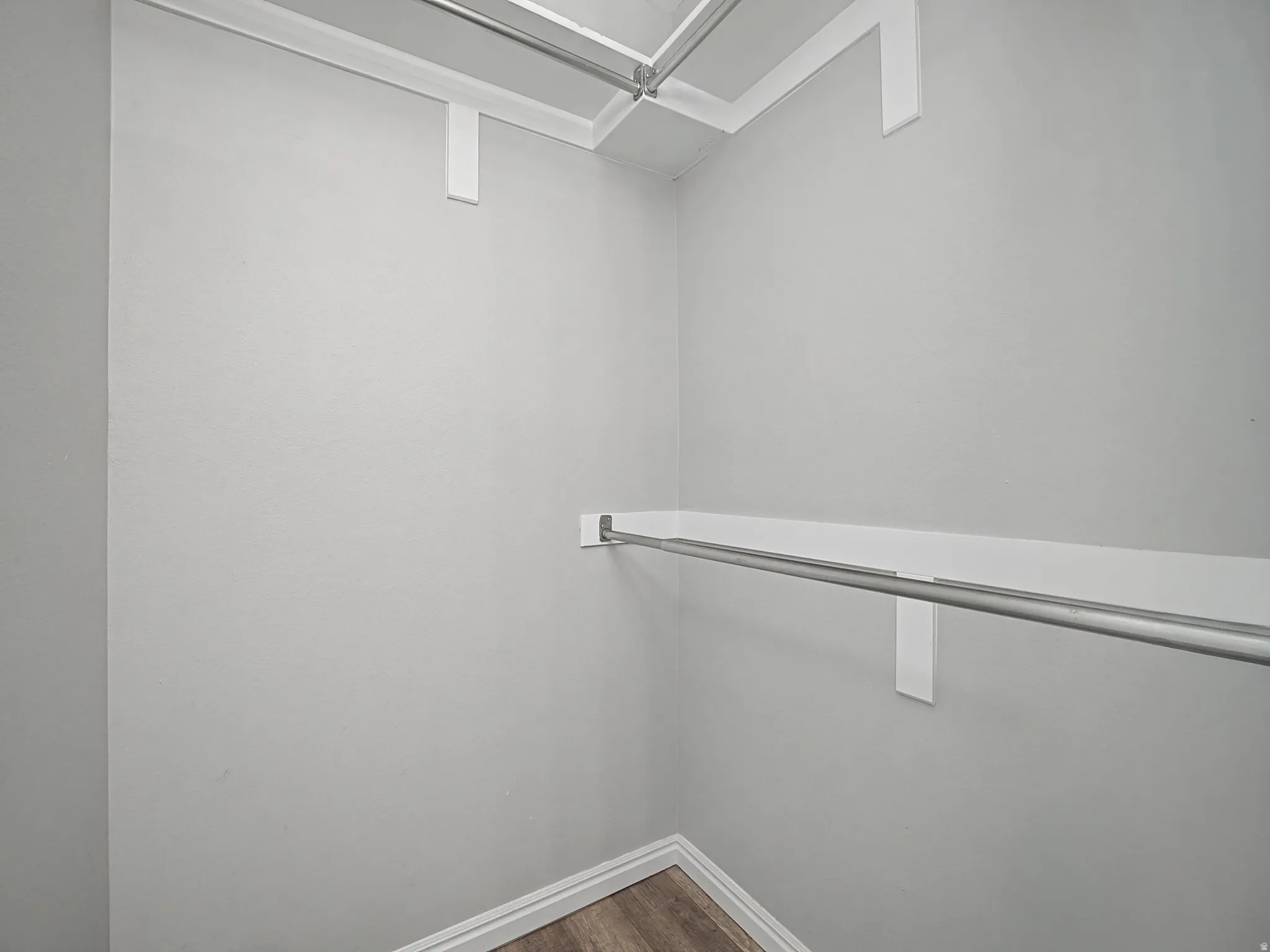 Walk in closet featuring dark wood-style flooring