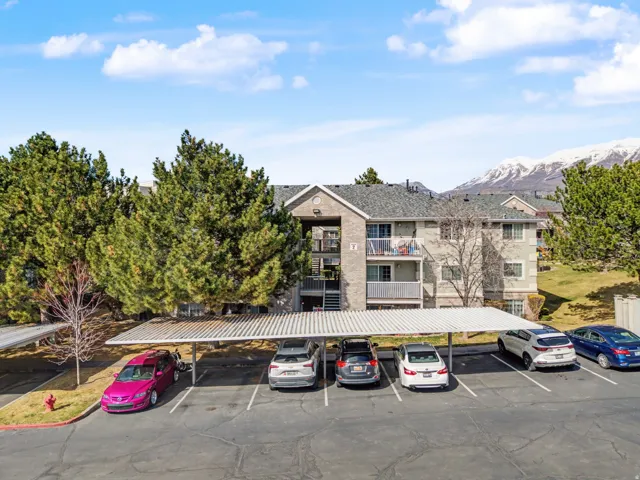 View of building exterior with a mountain view and covered parking