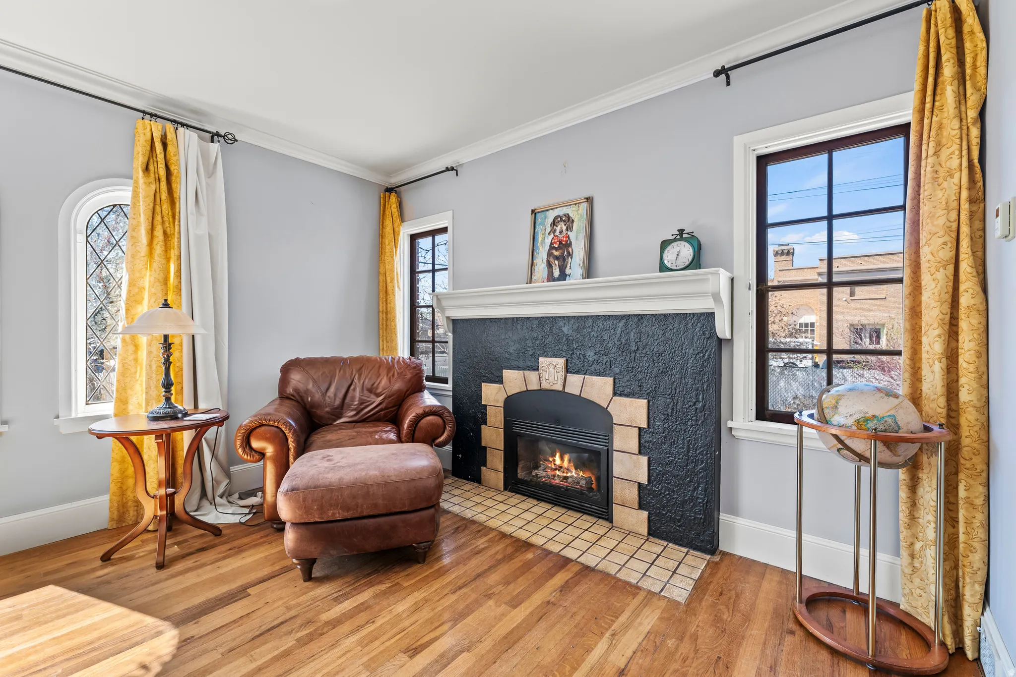 Living area with hardwood / wood-style flooring, a fireplace, and ornamental molding