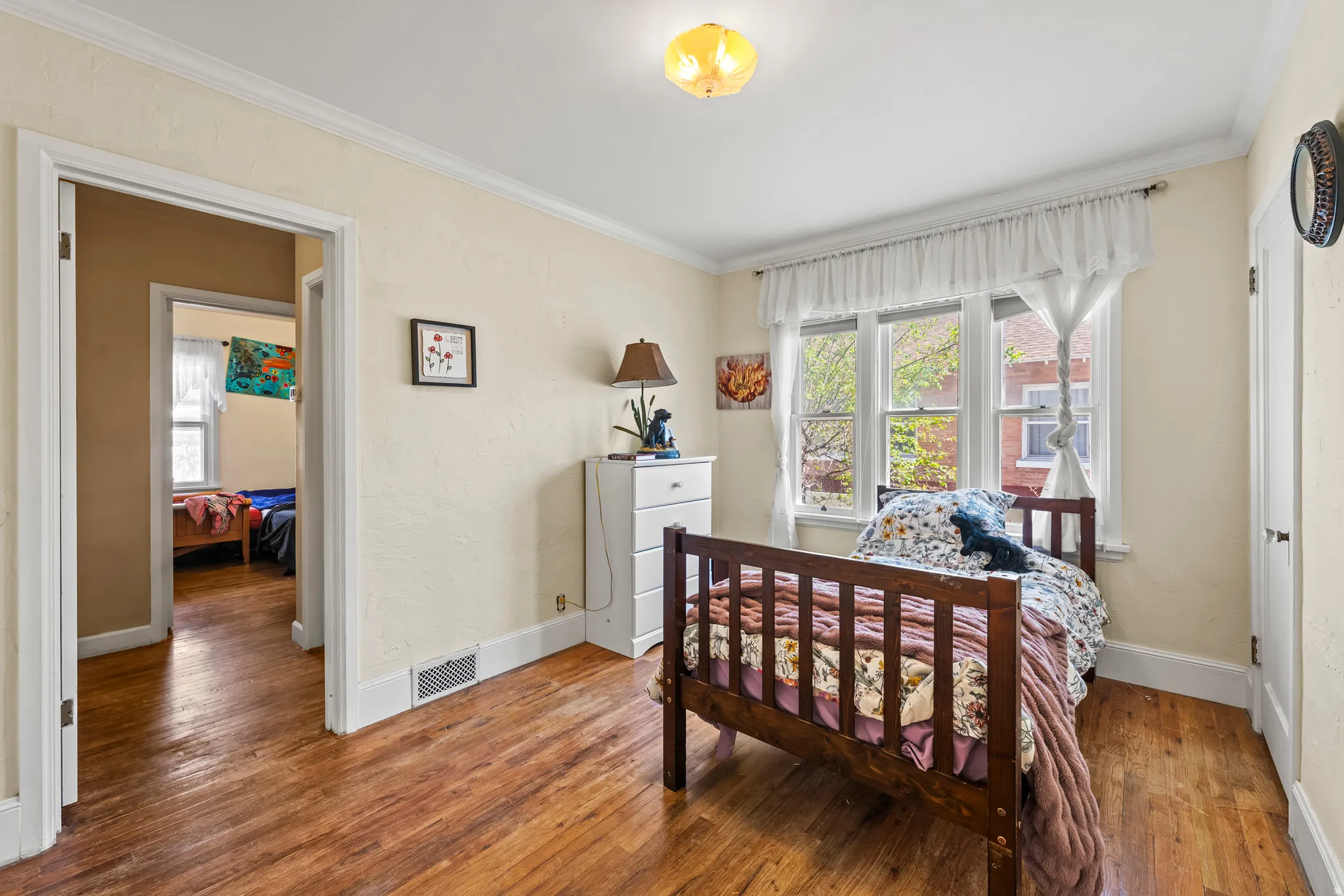 Bedroom featuring crown molding and wood finished floors