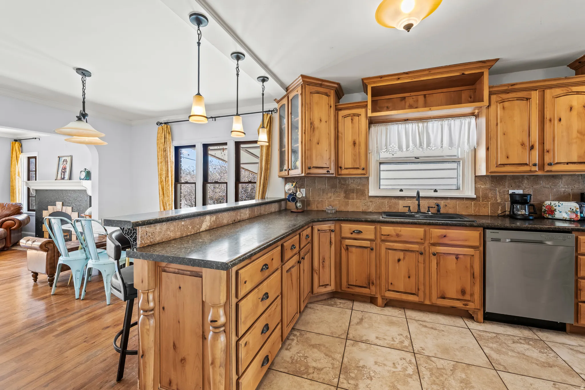 Kitchen featuring a peninsula, wood finish cabinets, a breakfast bar, and hanging light fixtures