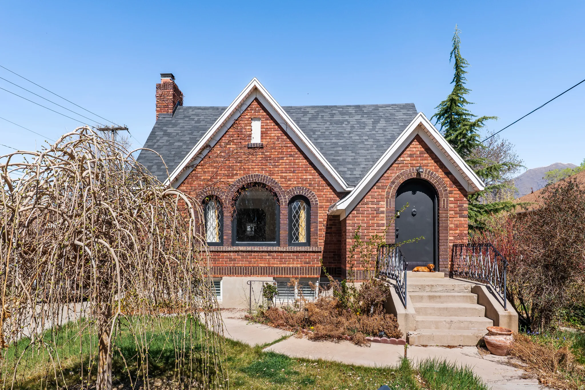 Tudor home with brick siding, a shingled roof, and a chimney