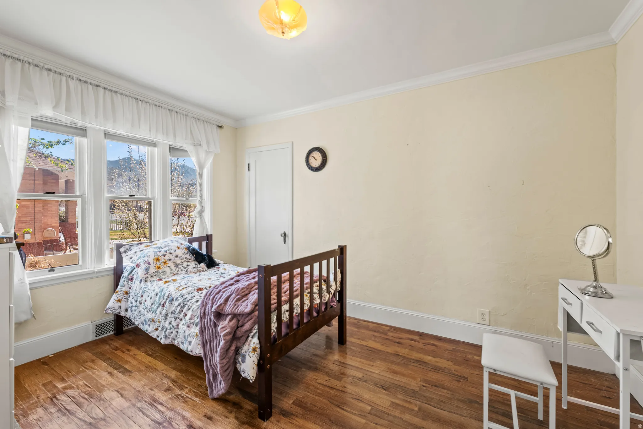 Bedroom with wood-type flooring and crown molding
