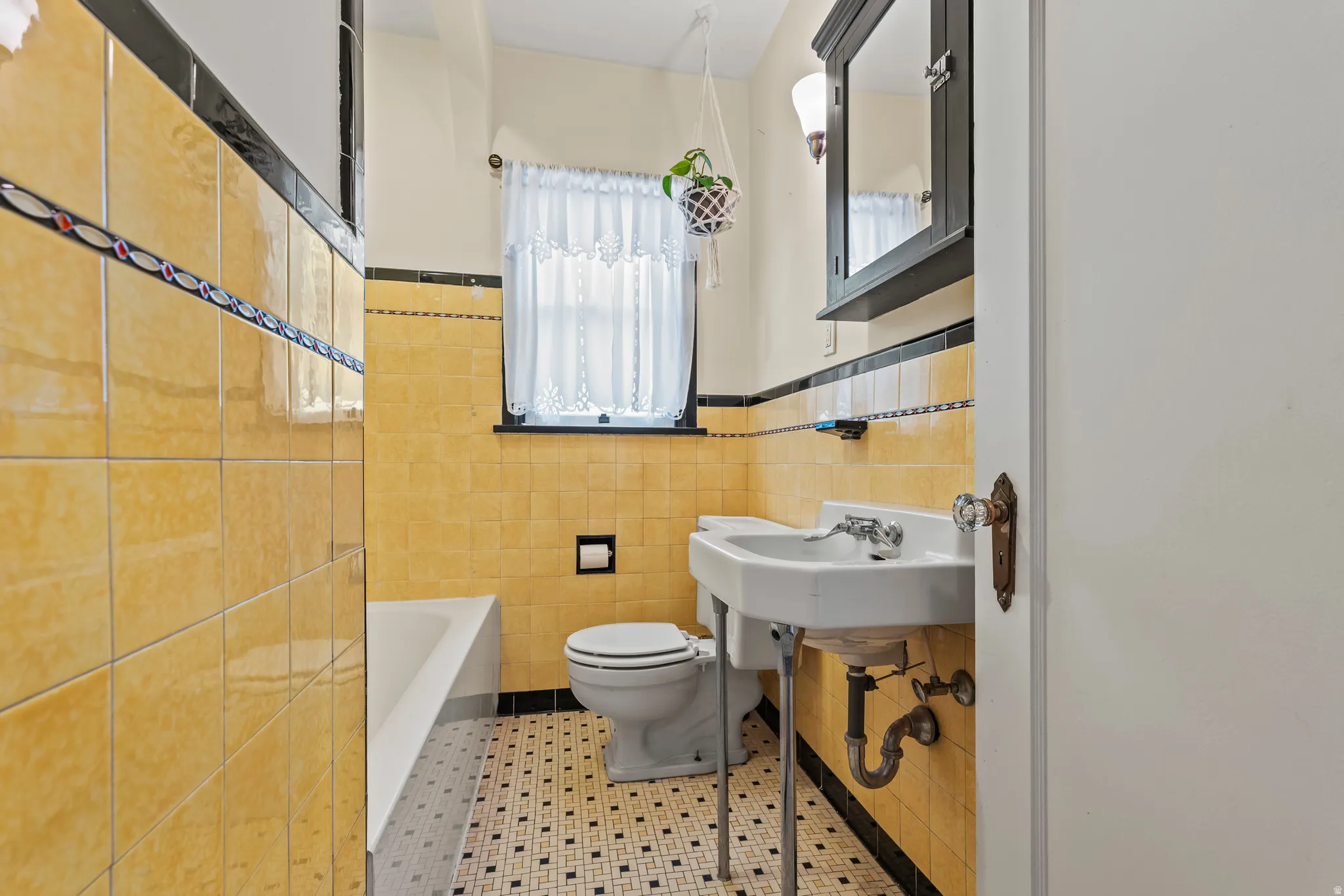 Bathroom featuring tile walls, a wainscoted wall, tile patterned flooring, and a tub to relax in