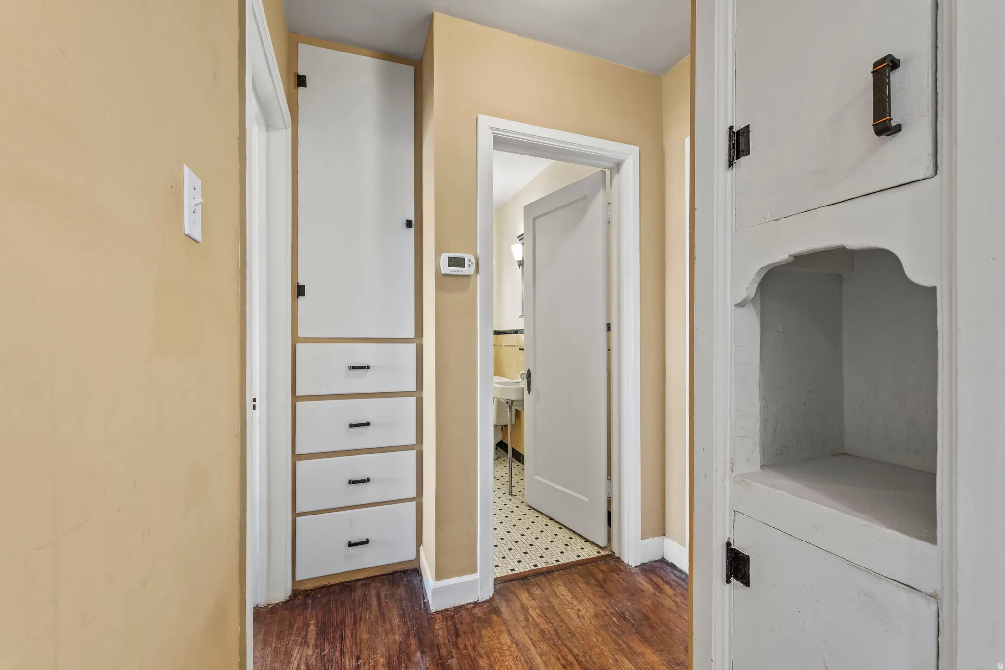 Corridor featuring dark wood-type flooring and baseboards