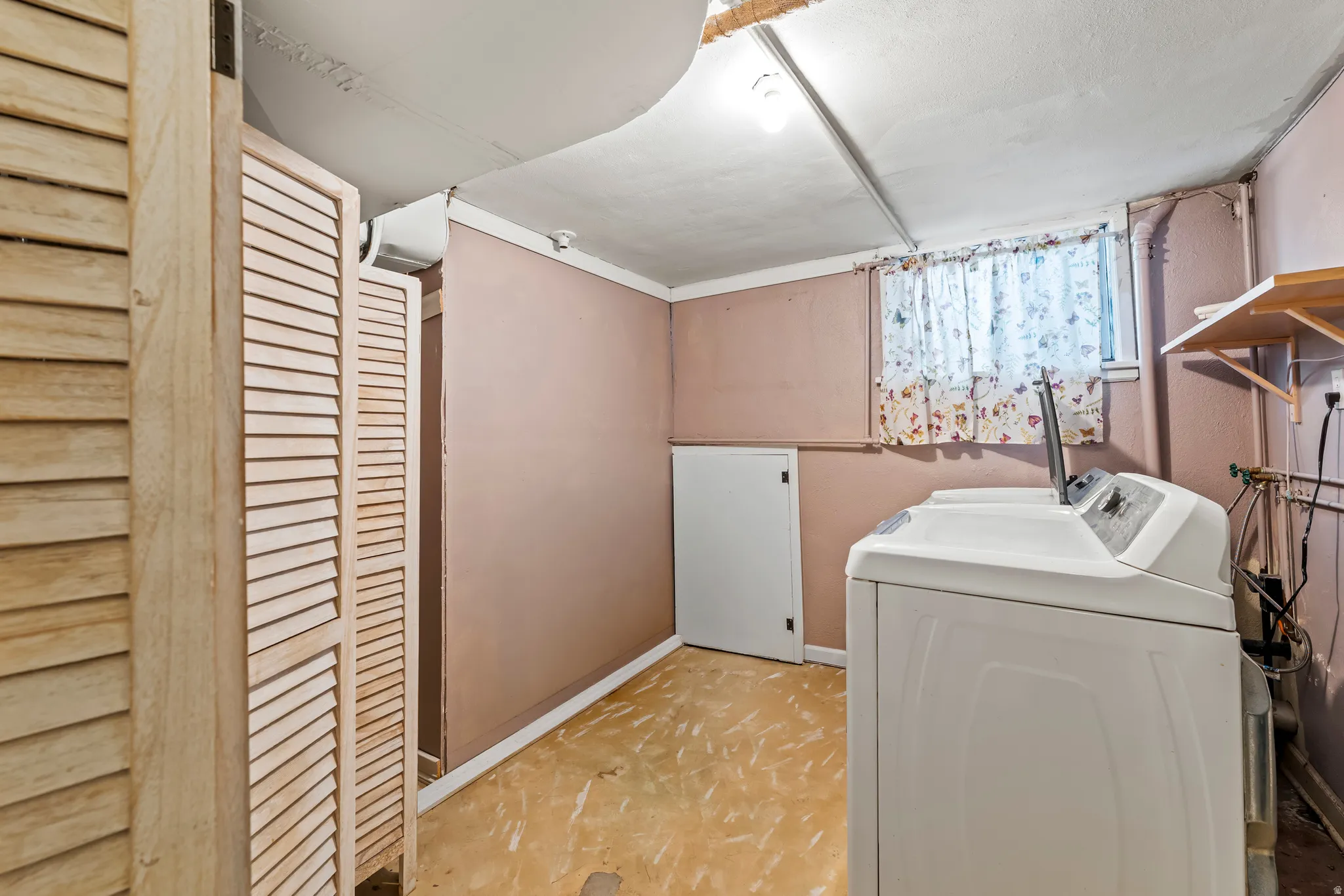 Laundry area featuring separate washer and dryer and baseboards
