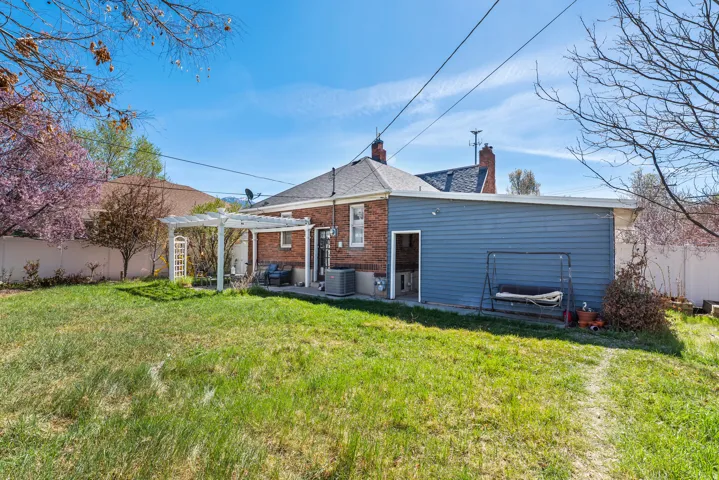 Rear view of house with a chimney, a patio, brick siding, and a pergola