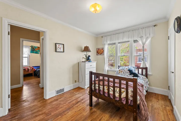 Bedroom featuring crown molding and wood finished floors