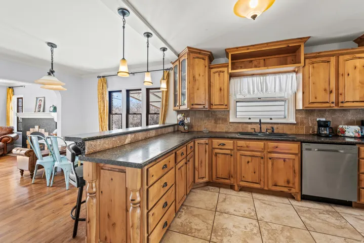 Kitchen featuring a peninsula, wood finish cabinets, a breakfast bar, and hanging light fixtures