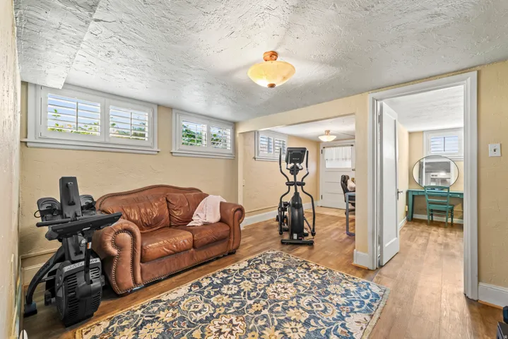 Living room featuring a textured wall, wood finished floors, a textured ceiling, and healthy amount of natural light
