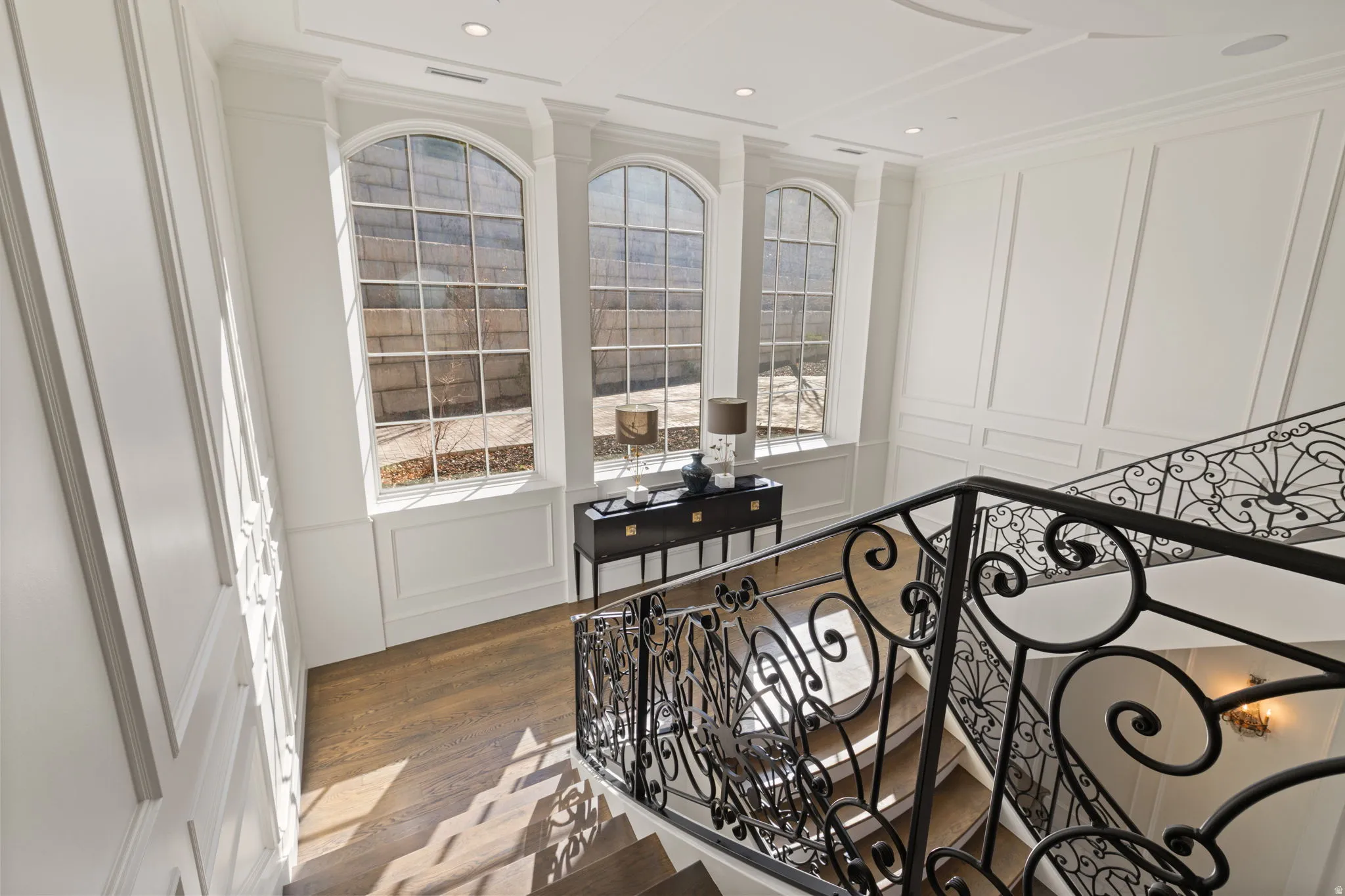 Bedroom with a decorative wall, wood finished floors, and crown molding