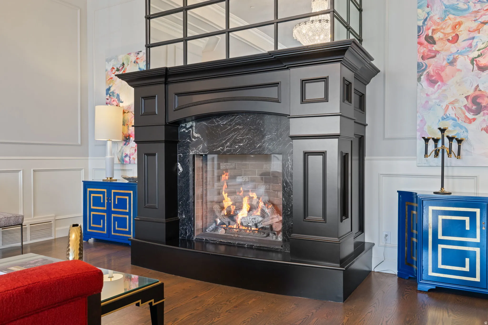 Detailed view of a decorative wall, wood finished floors, a premium fireplace, and wainscoting