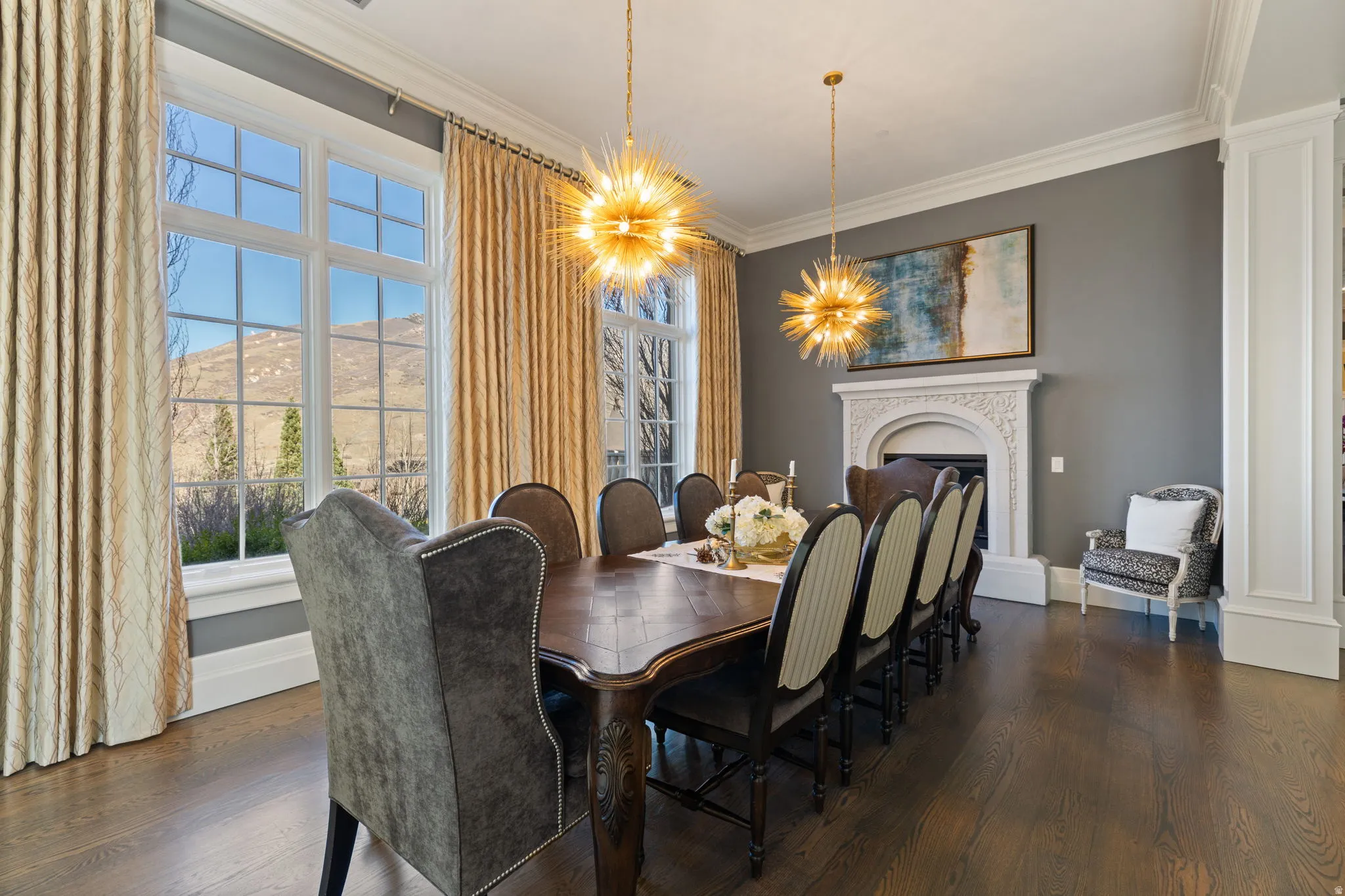 Dining space with suspended lighting, ornamental molding, dark wood-style flooring, and a fireplace