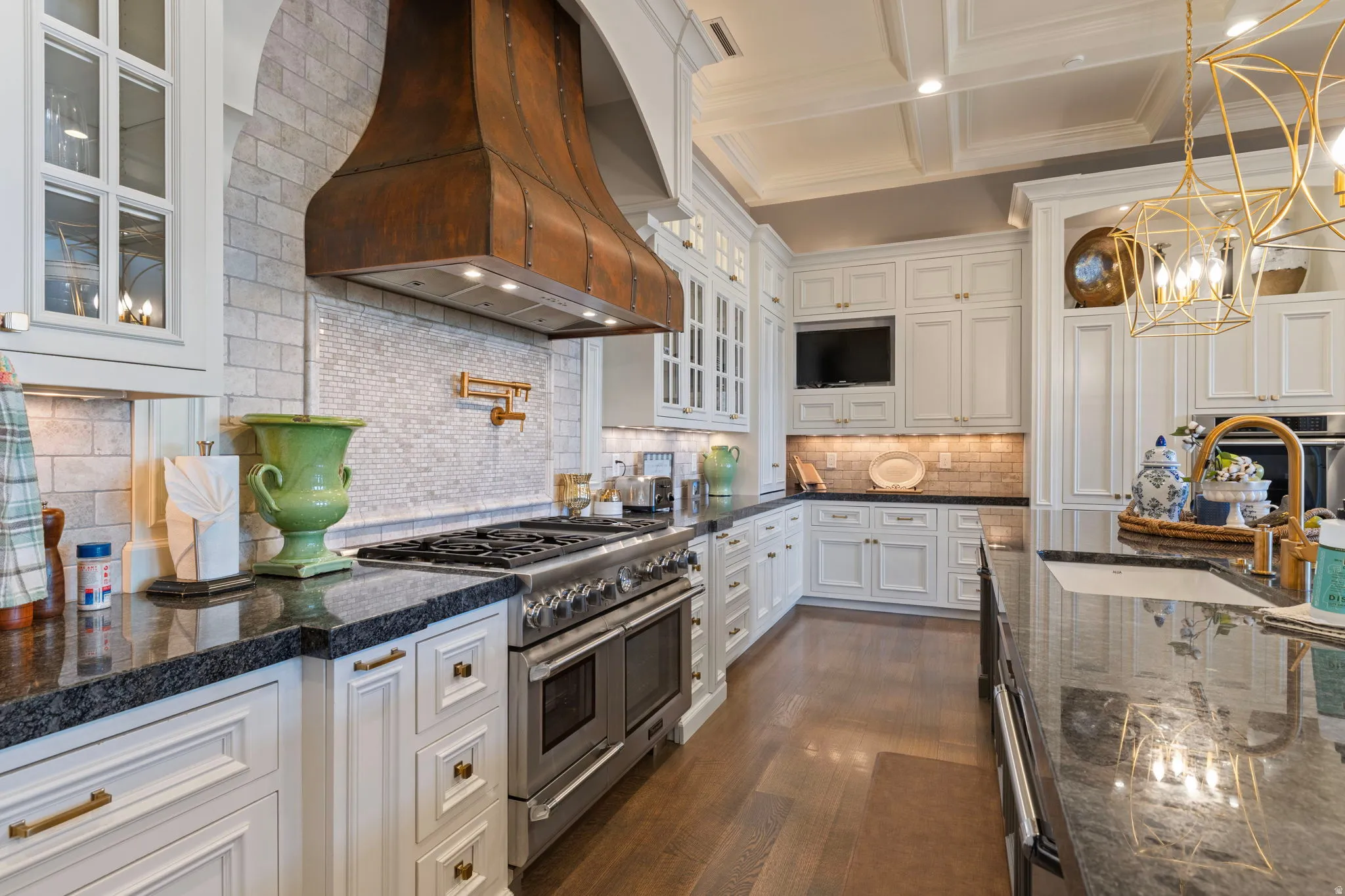 Kitchen featuring glass insert cabinets, white cabinets, double oven range, extractor fan, and tasteful backsplash