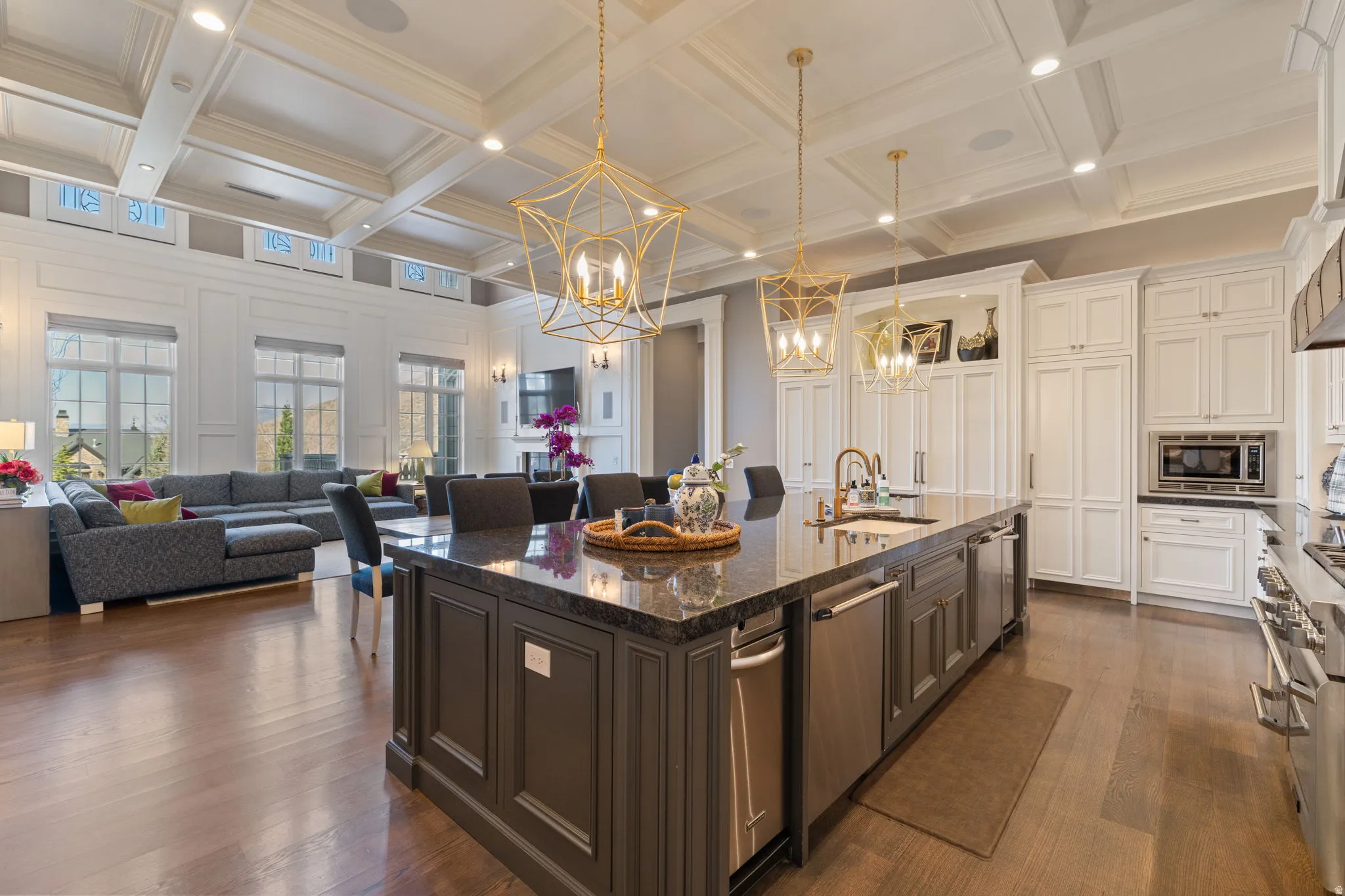 Dual tone kitchen with dark stone countertops, open floor plan, dual tone cabinets, dark wood finished floors, and a large island
