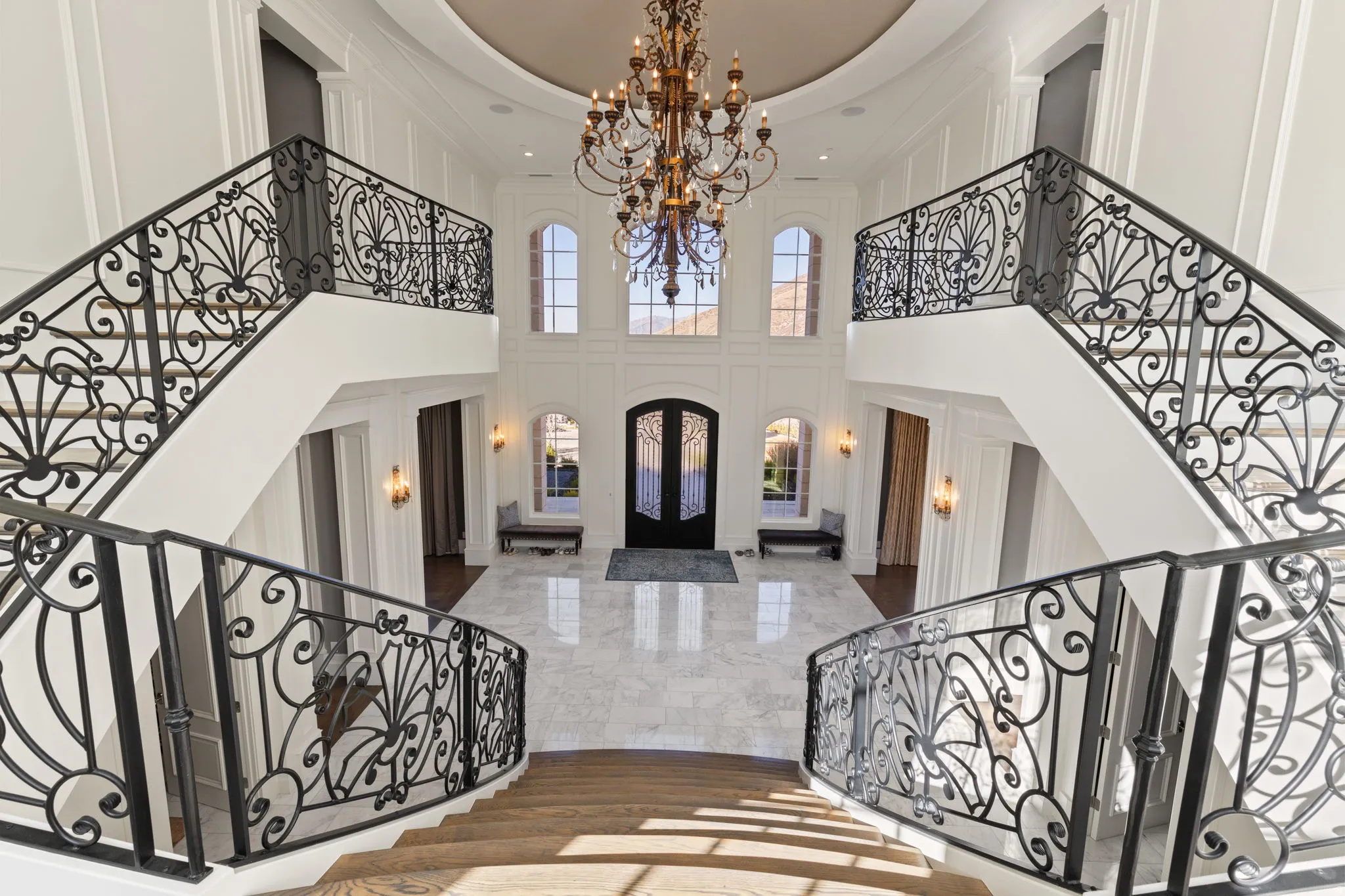 Foyer entrance featuring a chandelier, dark marble finish floors, a decorative wall, and a high ceiling