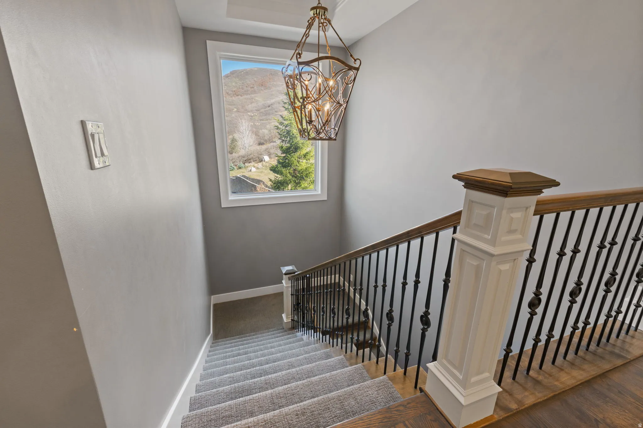 Stairway with a chandelier and wood finished floors