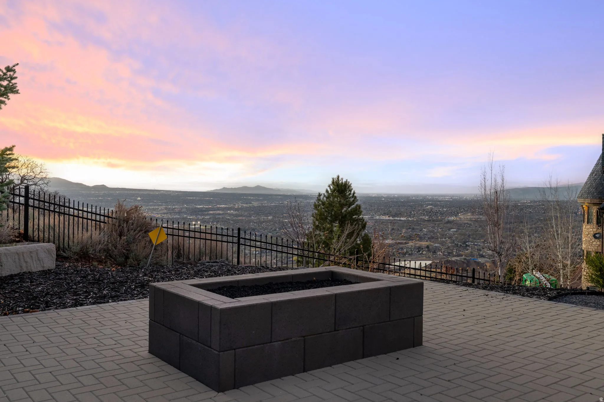 Patio terrace at dusk with a fenced backyard, a patio area, and a mountain view