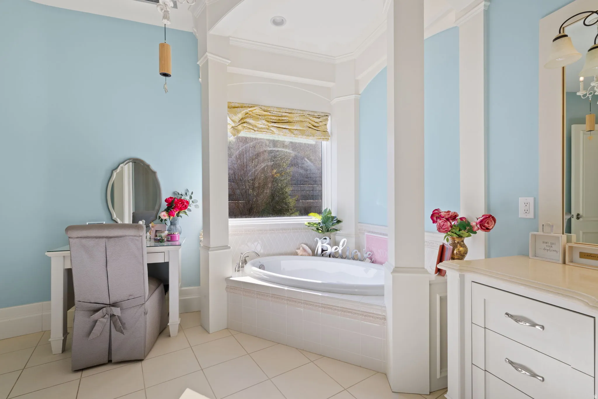 Bathroom featuring a garden tub, vanity, ornamental molding, and light tile patterned flooring