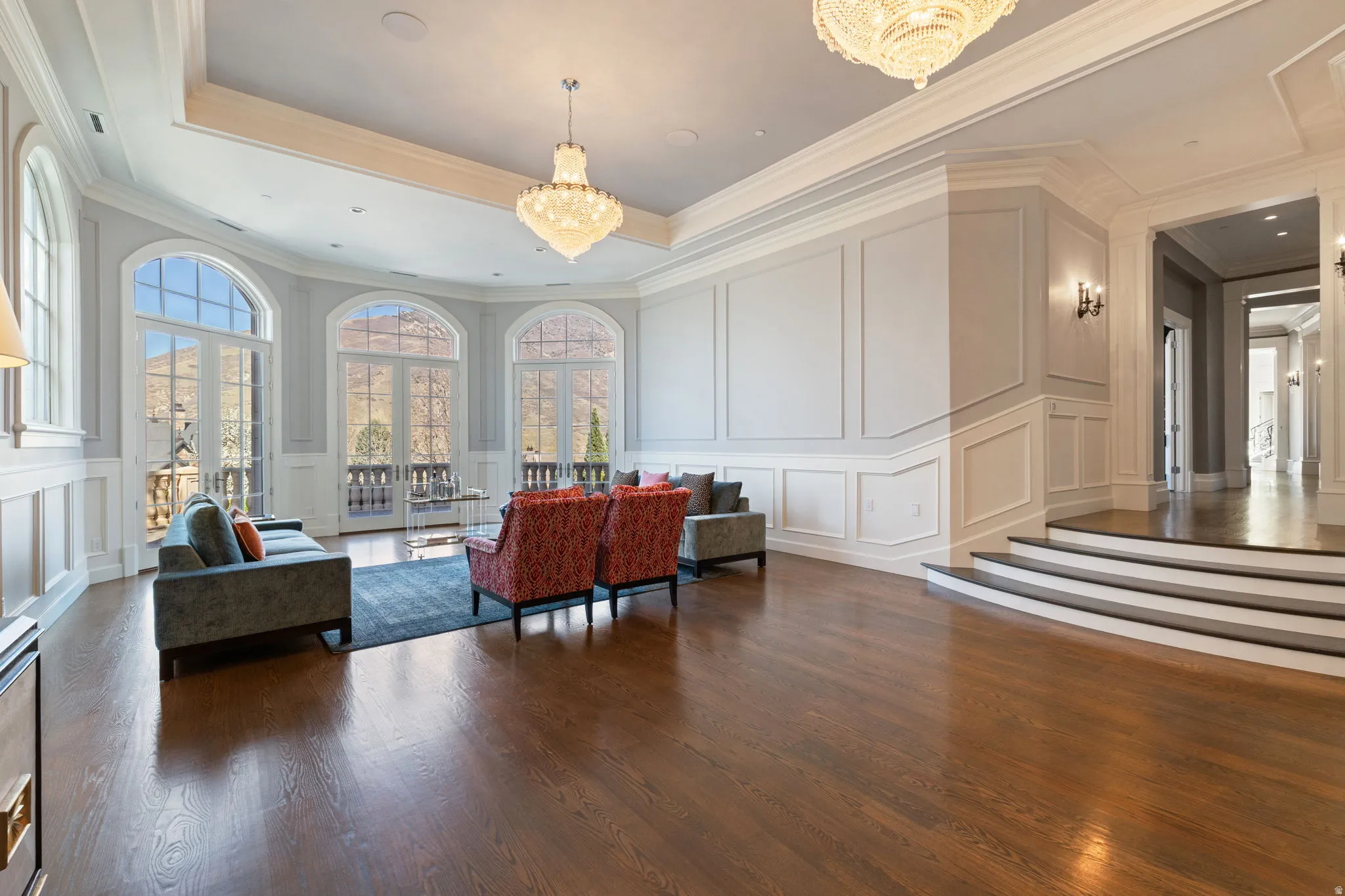 Lobby featuring a decorative wall, ornamental molding, and a raised ceiling