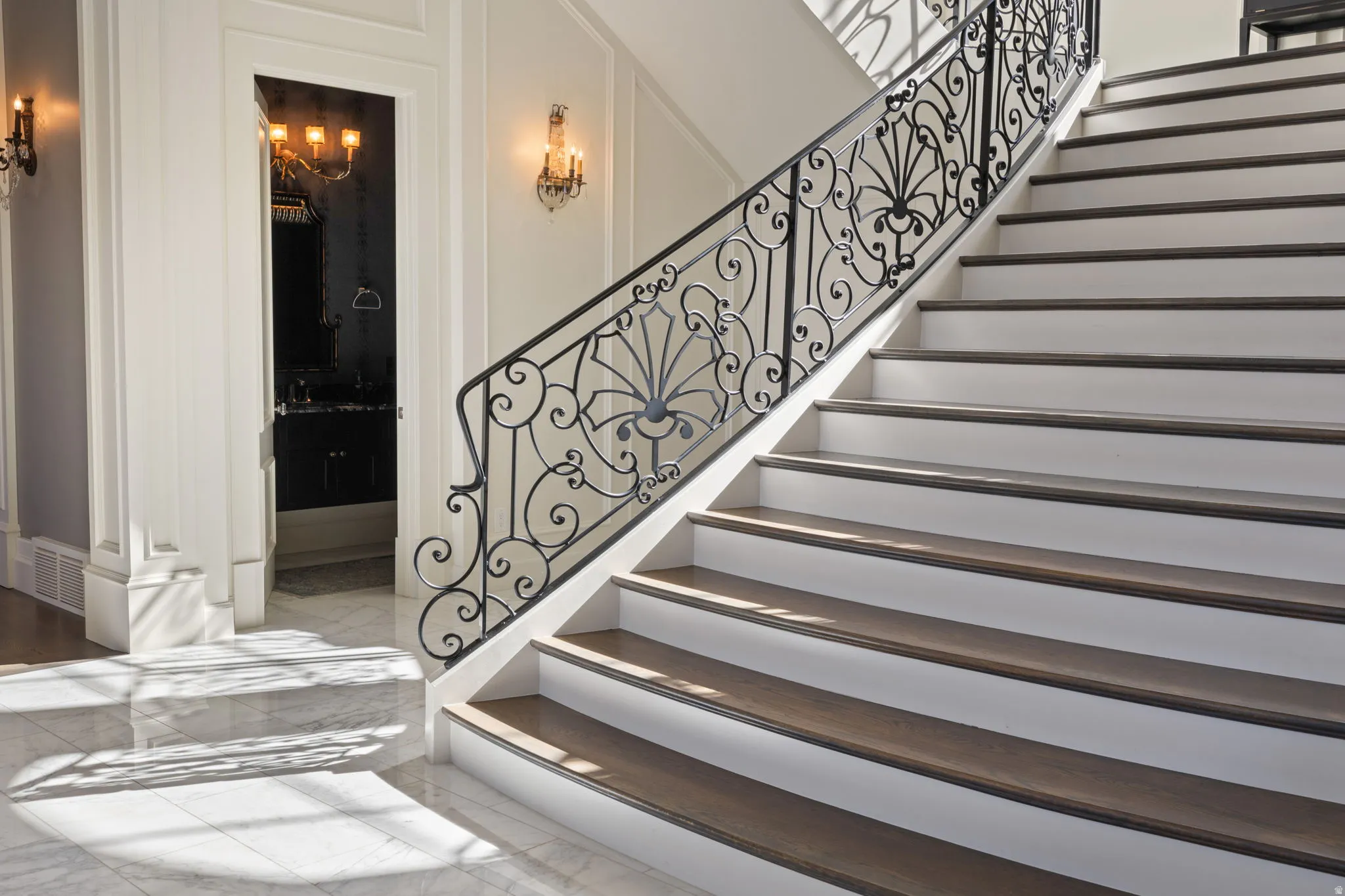 Stairs with a decorative wall and marble tiled flooring
