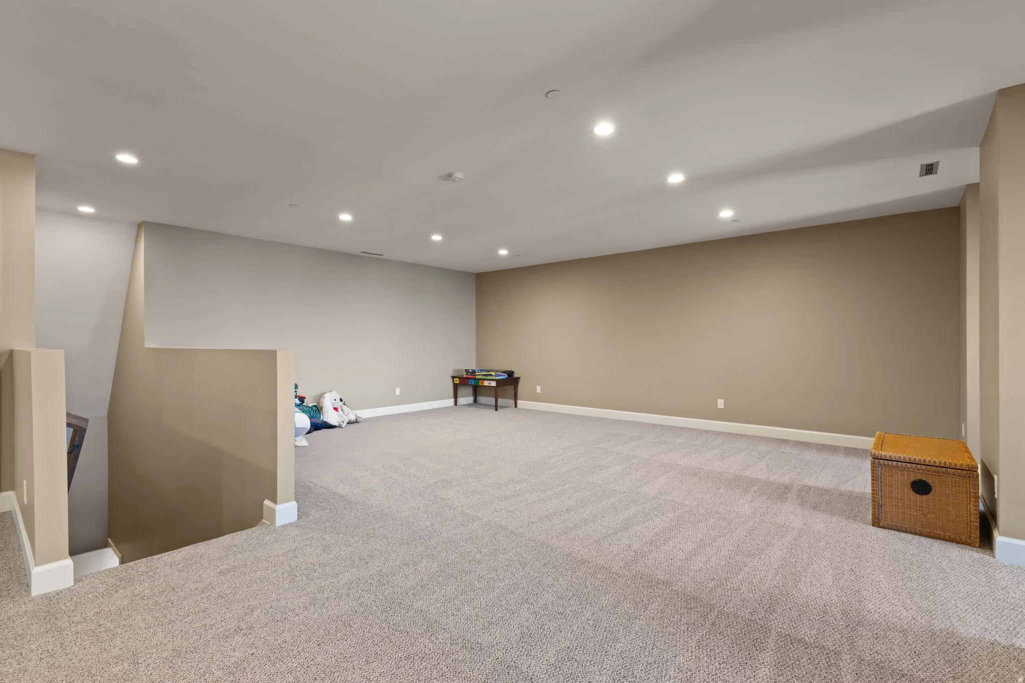 Below grade area featuring recessed lighting and light colored carpet
