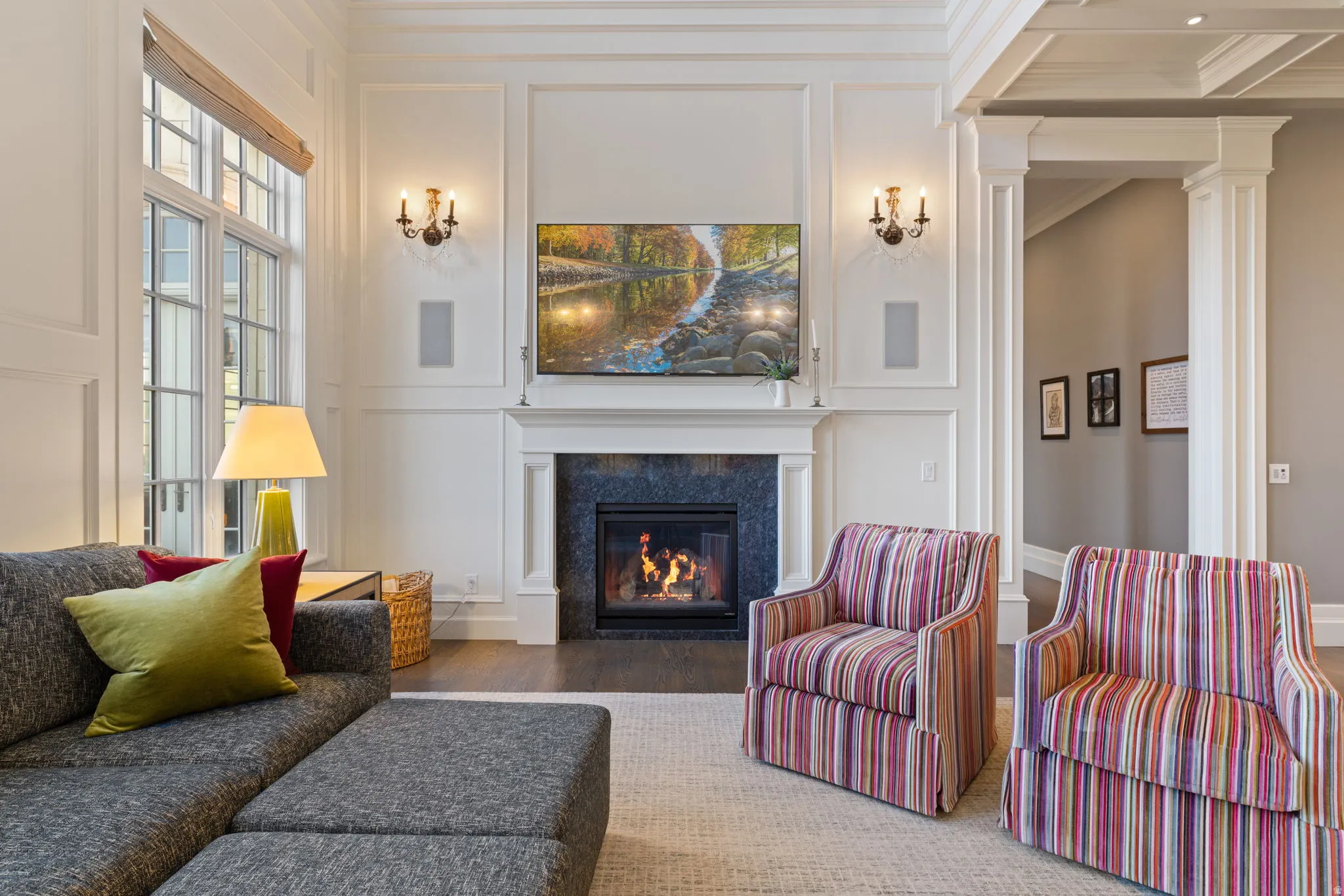 Living area with a decorative wall, wood finished floors, a premium fireplace, and ornamental molding