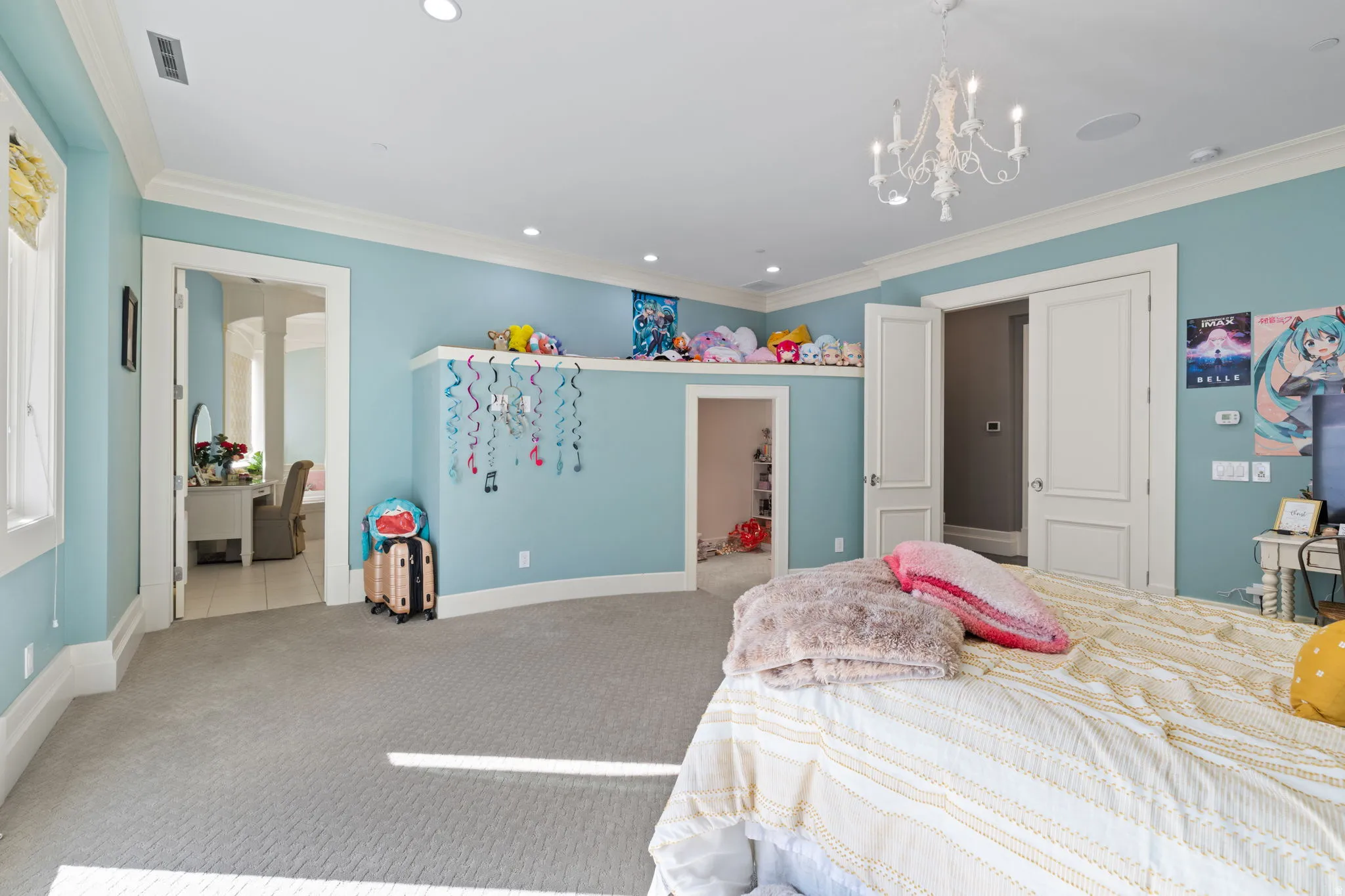 Bedroom with crown molding, light carpet, and a chandelier